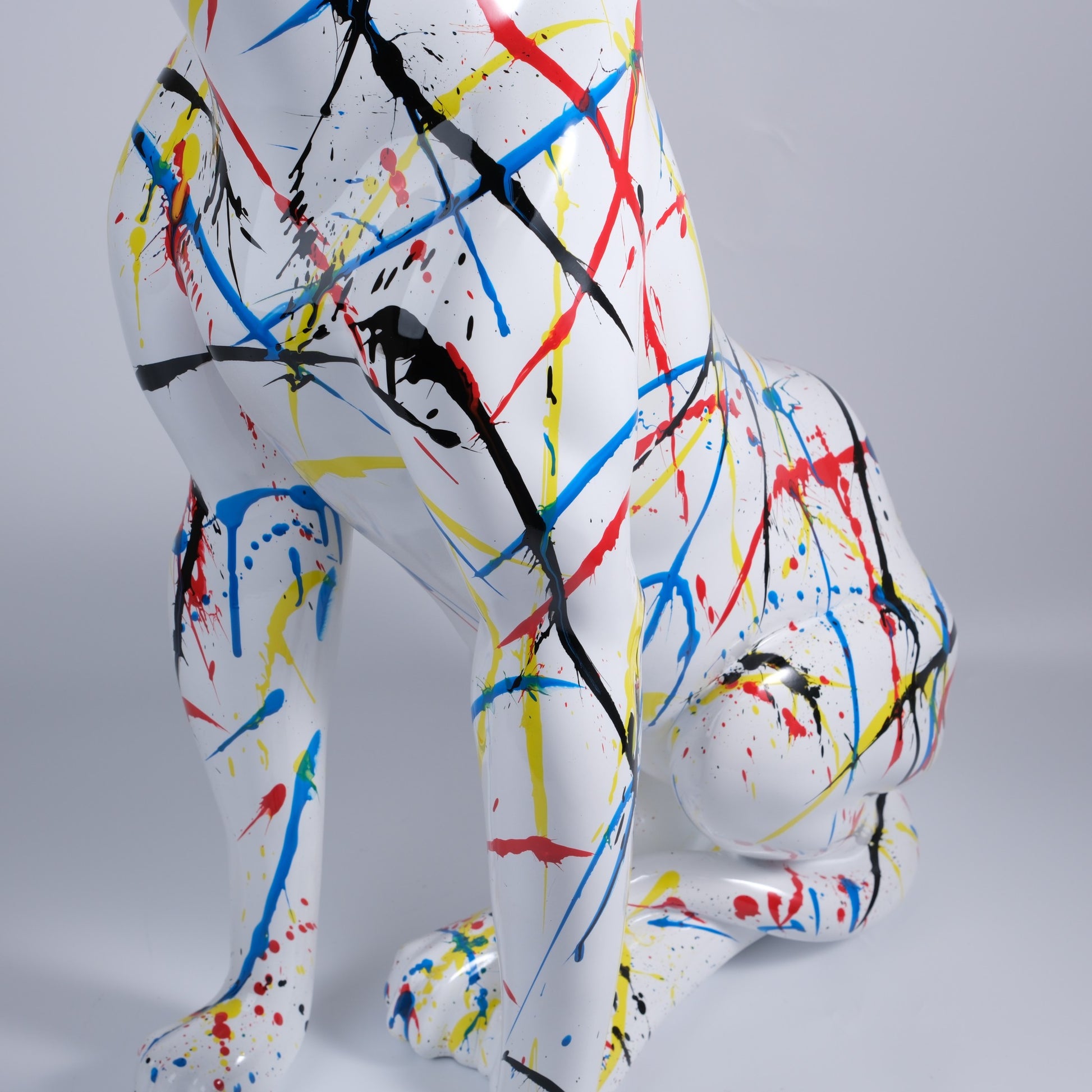 White resin dog statue with vibrant paint splatters
