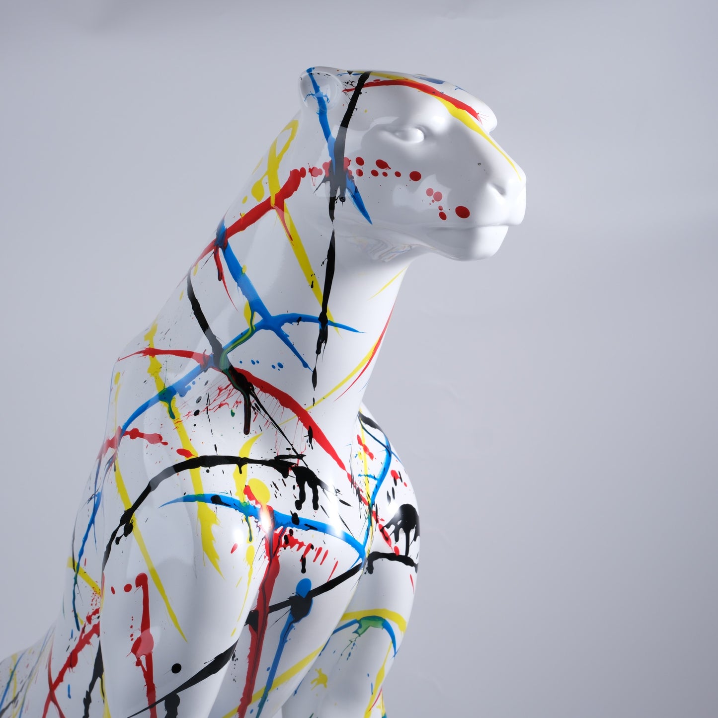 White ceramic panther statue with abstract paint splatter