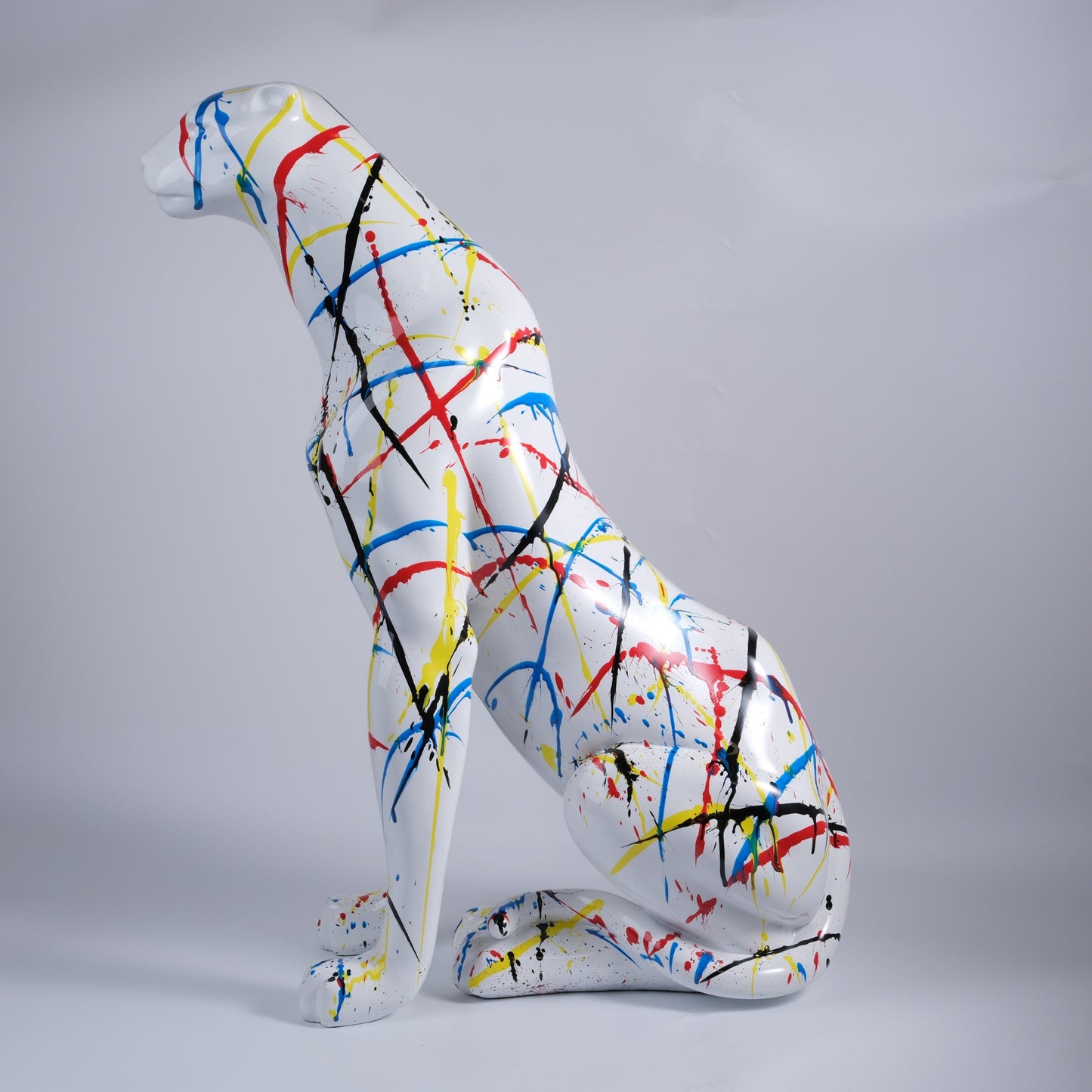 White abstract cheetah sculpture with splatter paint accents in red blue and yellow