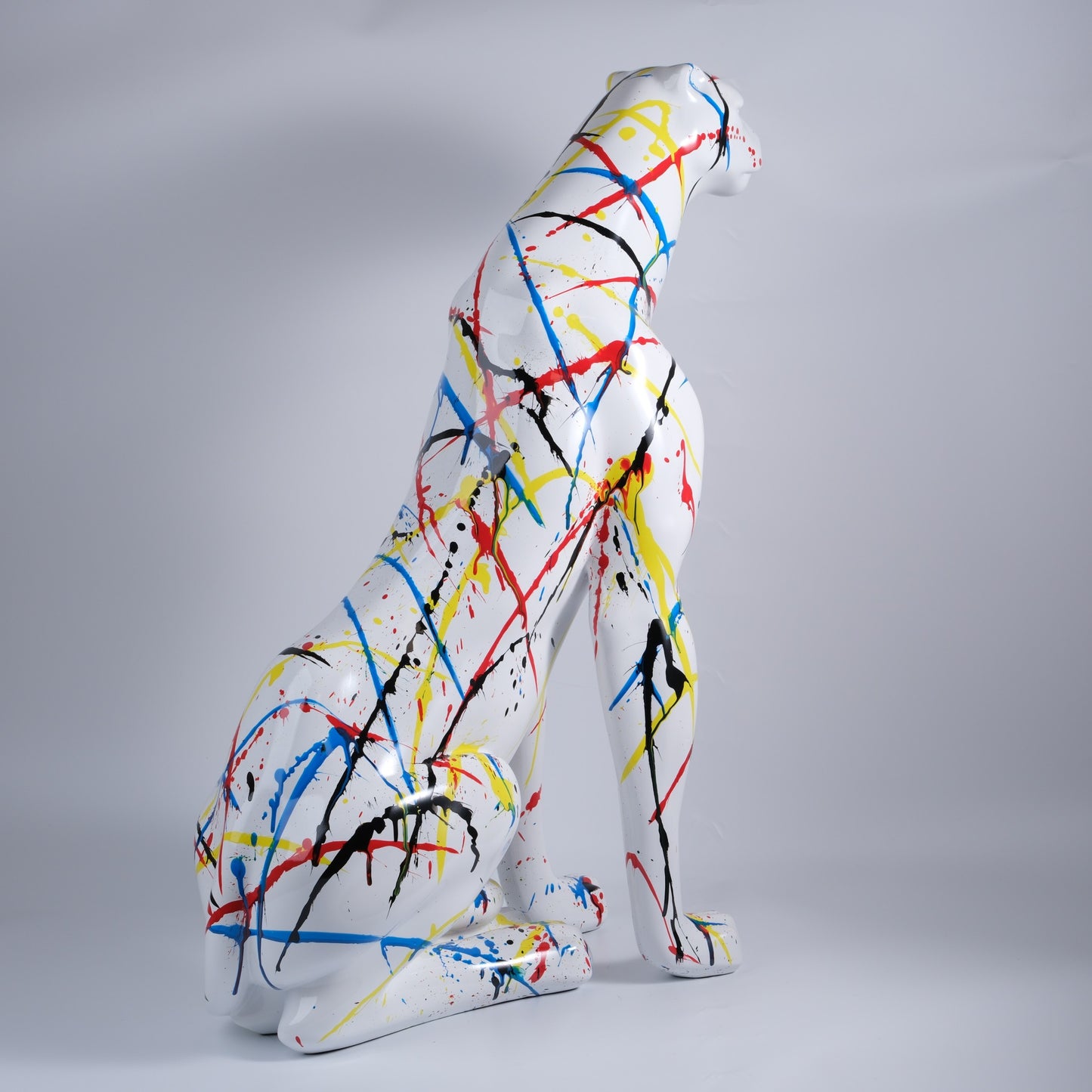 White cheetah sculpture with abstract paint splatter art