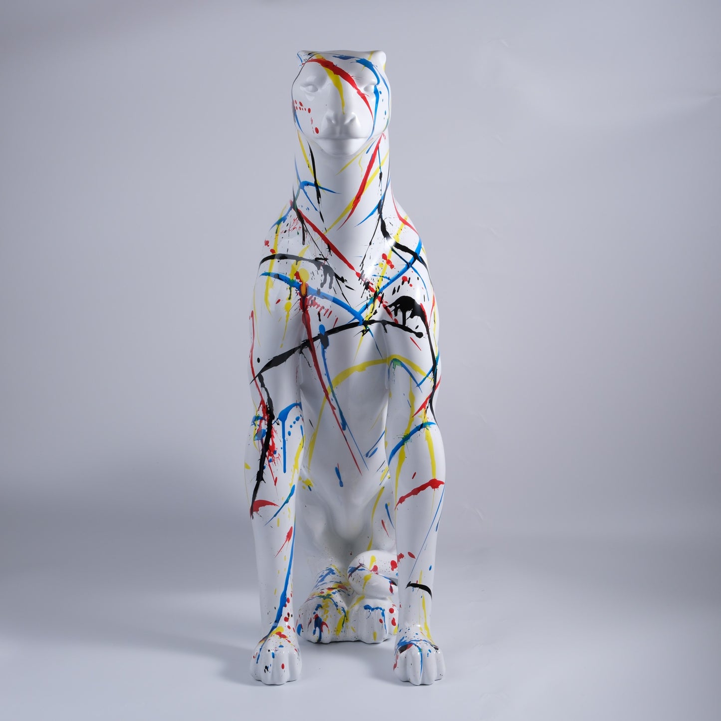 White ceramic leopard statue with colorful paint splatter