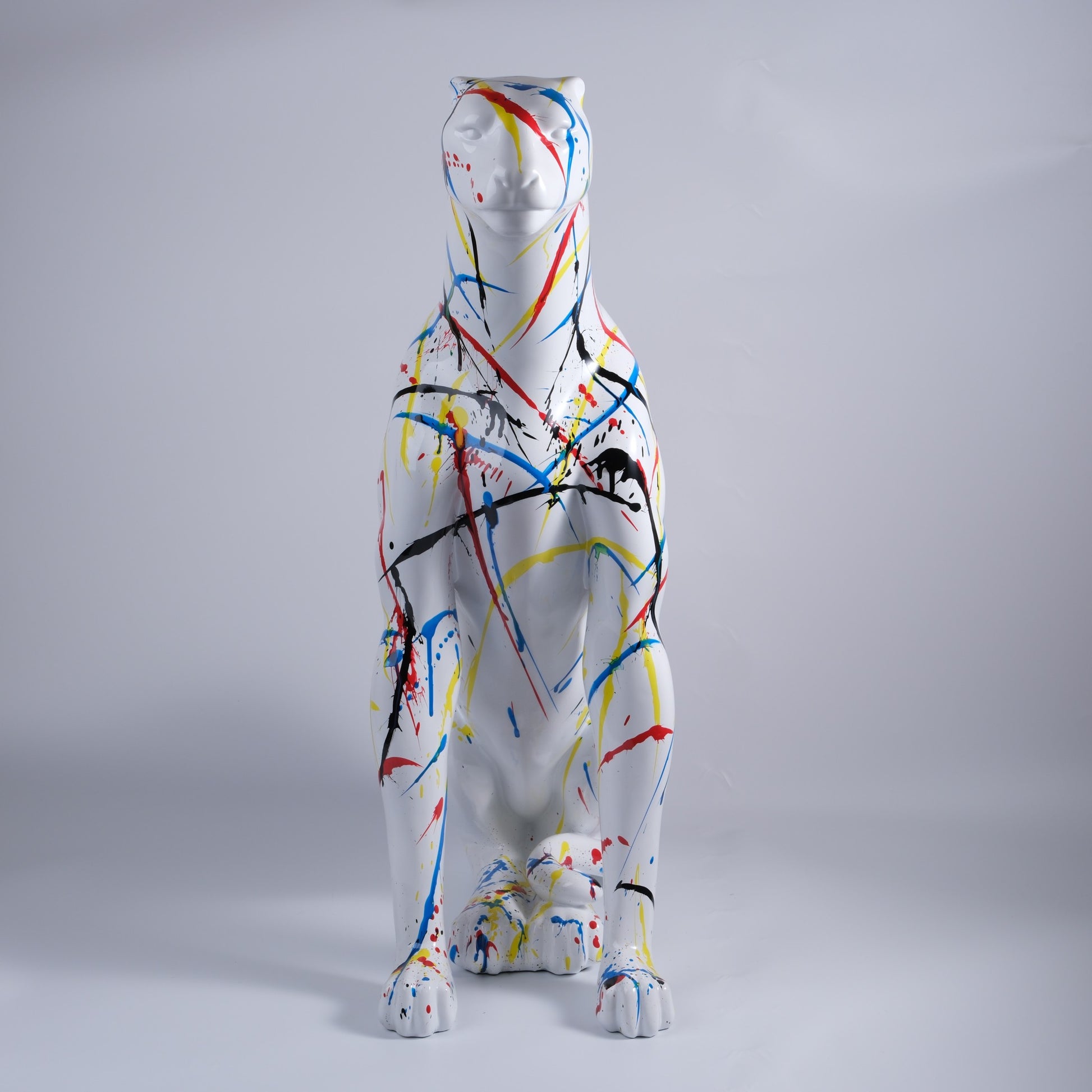 White ceramic leopard statue with colorful paint splatter