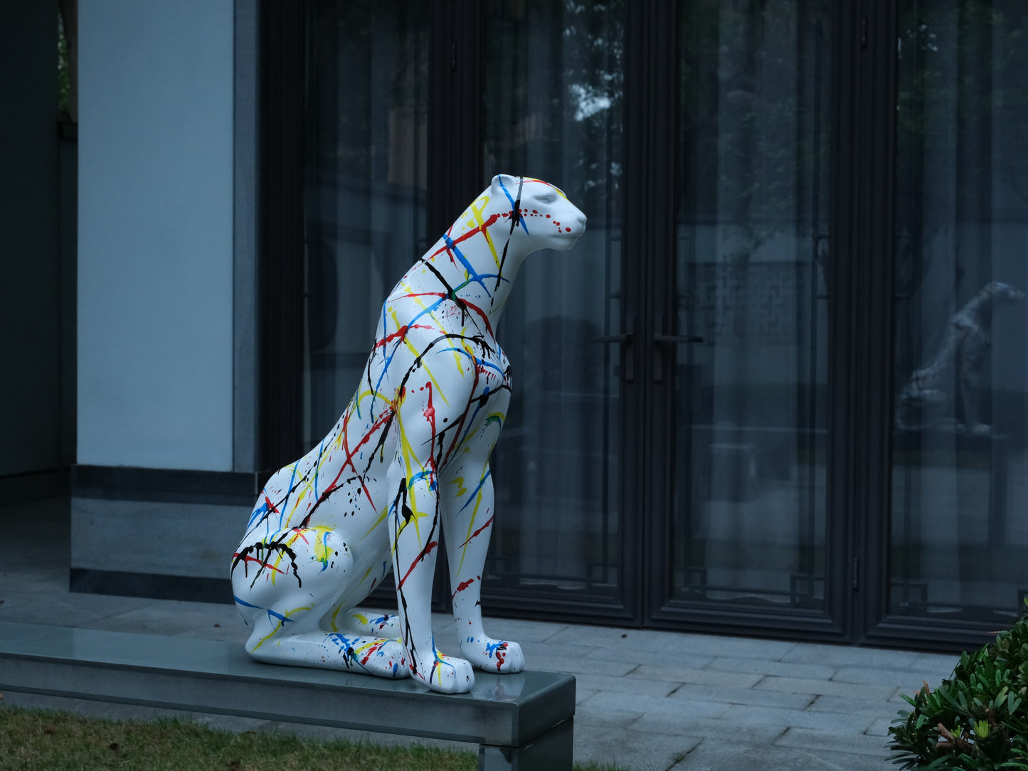 White cheetah sculpture with abstract colorful paint splatter modern art decor