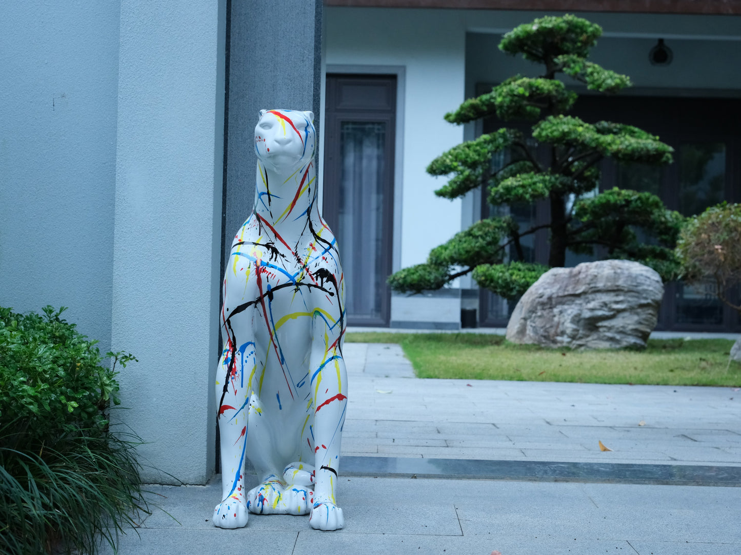 White leopard statue with abstract colorful paint splatters