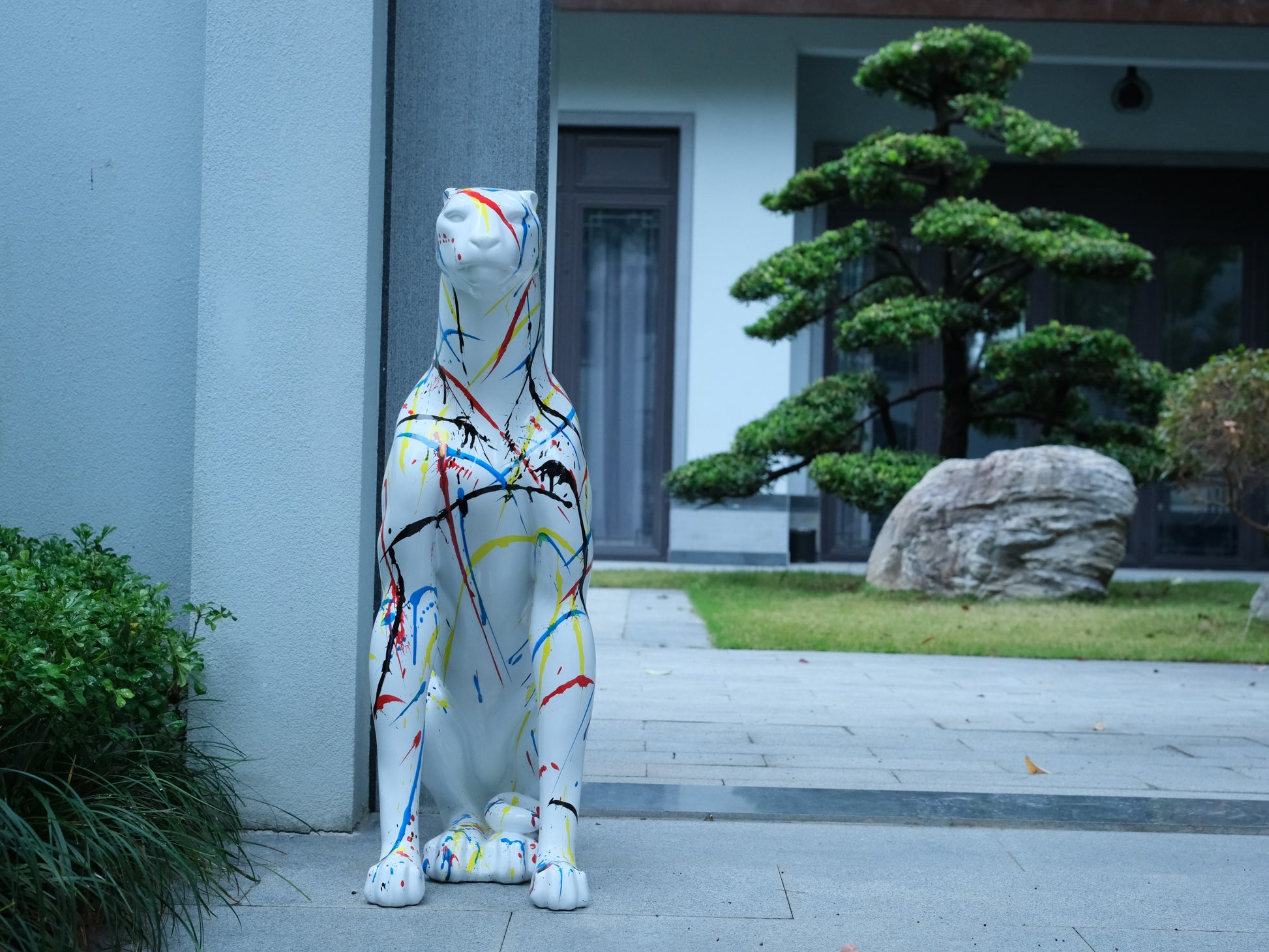 White leopard statue with abstract colorful paint splatters