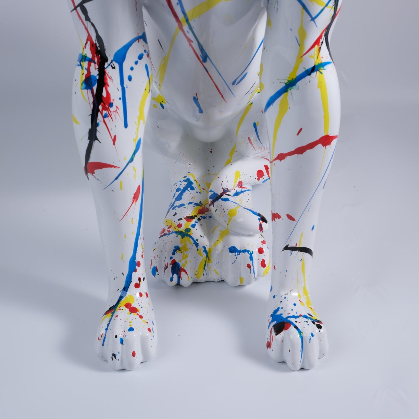 White dog sculpture with vibrant abstract paint splatters modern decor