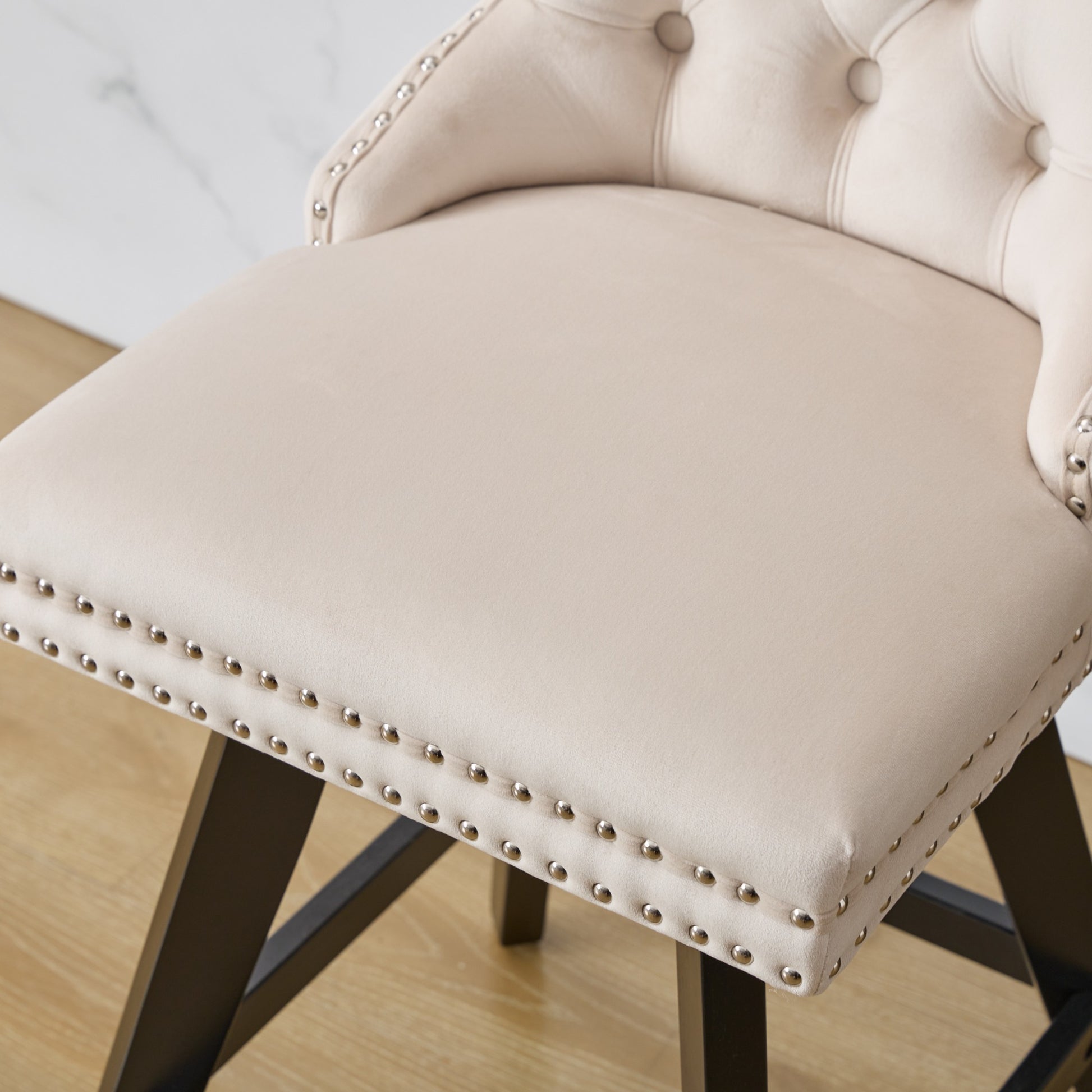 Tufted cream velvet bar stool with nailhead trim and dark wood legs