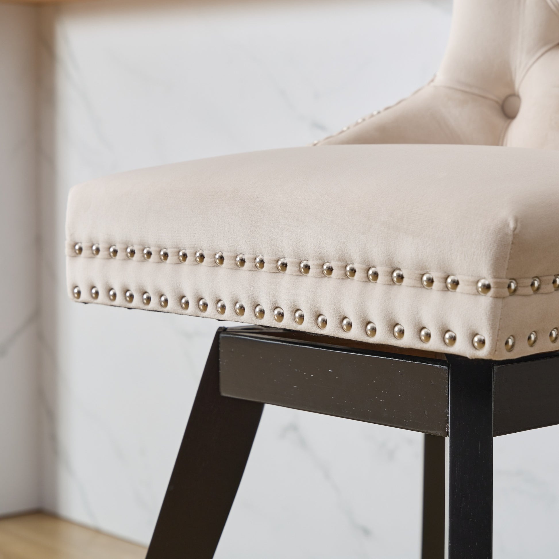 Beige velvet counter stool with nailhead trim and dark wood legs