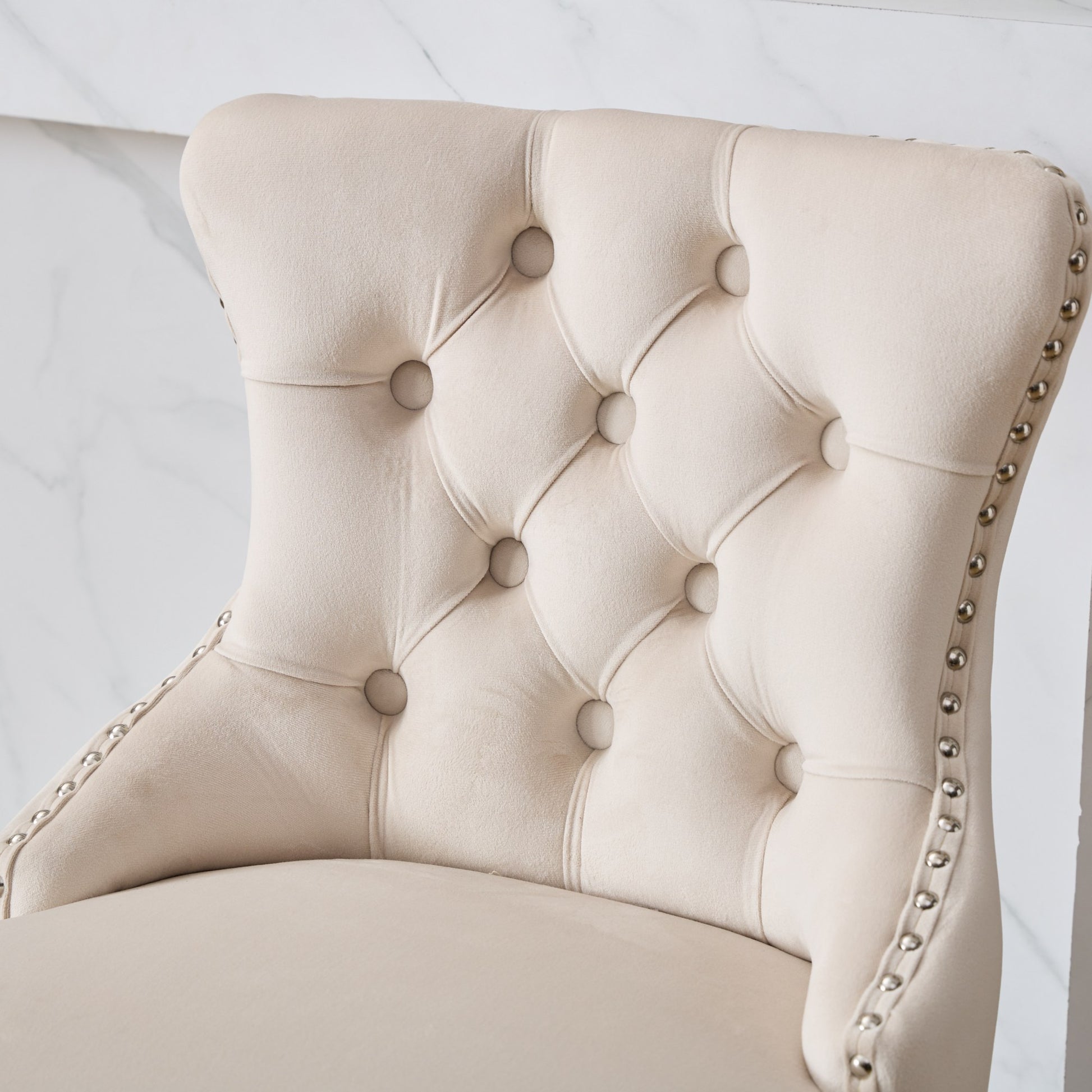Beige velvet accent chair with button tufting and silver nailhead trim