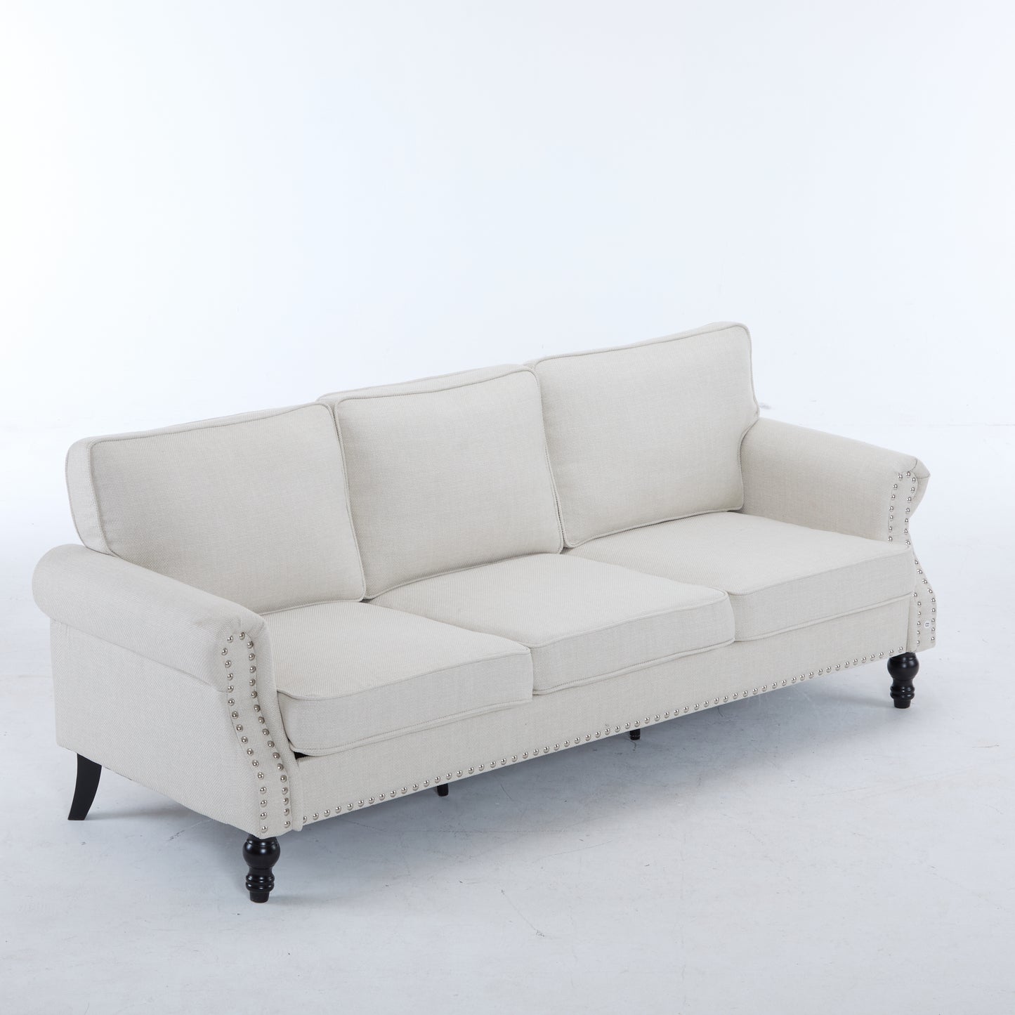 Beige linen sofa with studded trim and dark wooden legs