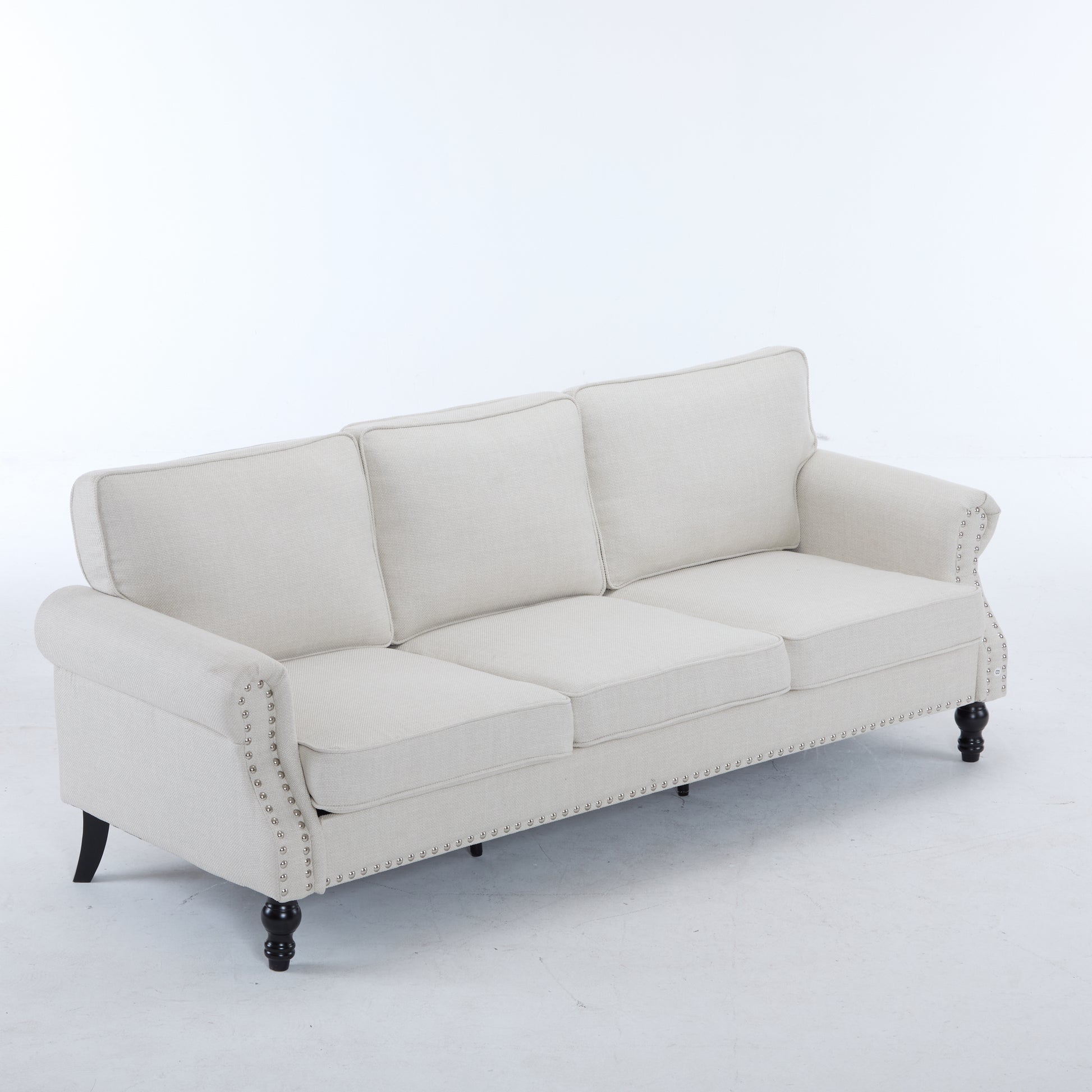 Beige linen sofa with studded trim and dark wooden legs