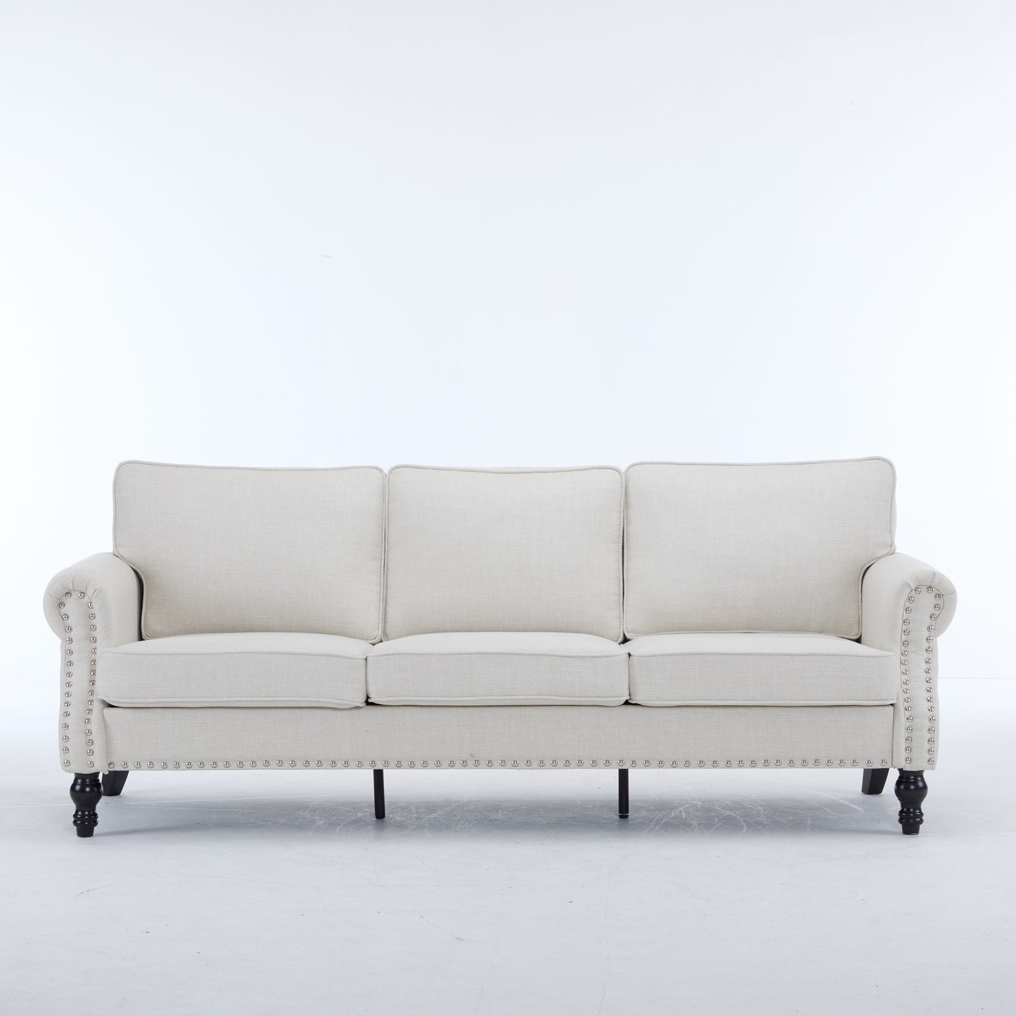 Cream fabric sofa with tufted back and studded arms