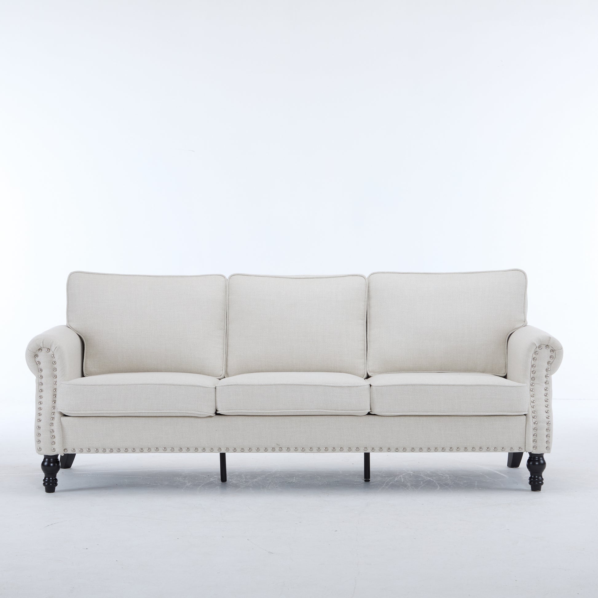 Cream fabric sofa with tufted back and studded arms