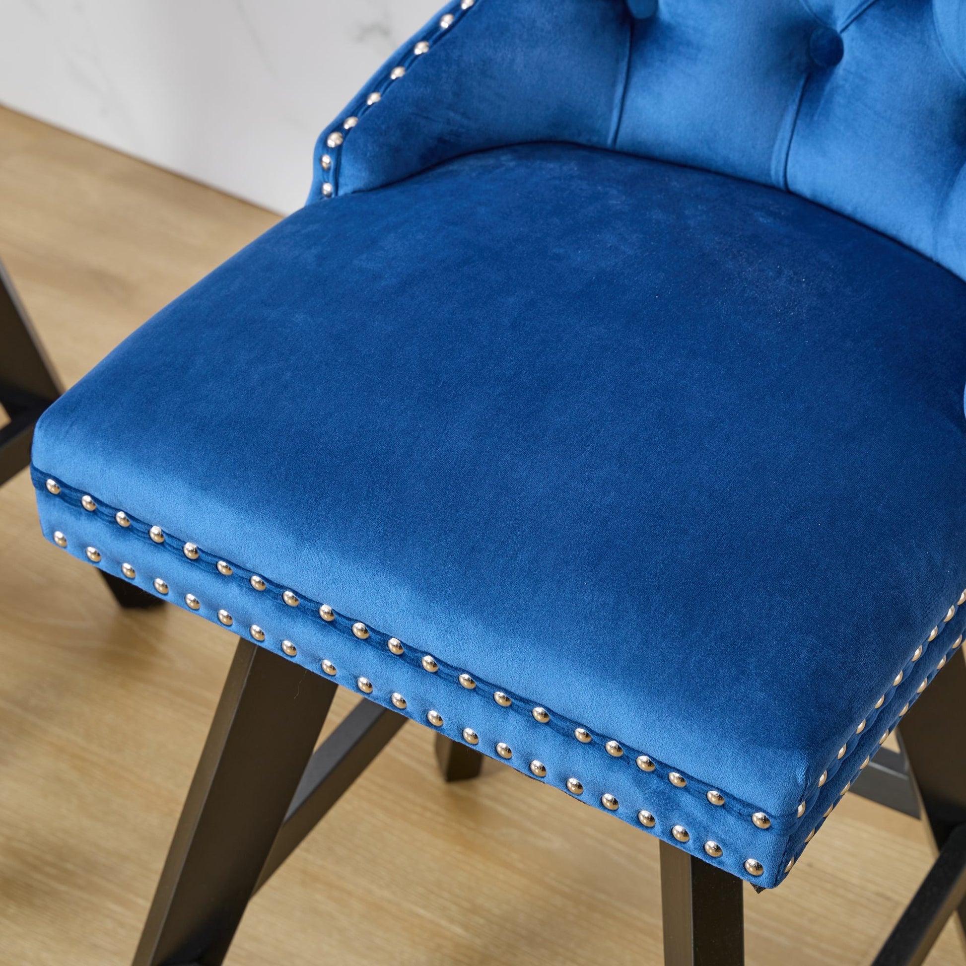 Tufted royal blue velvet bar stool with silver nailhead trim and dark wood legs