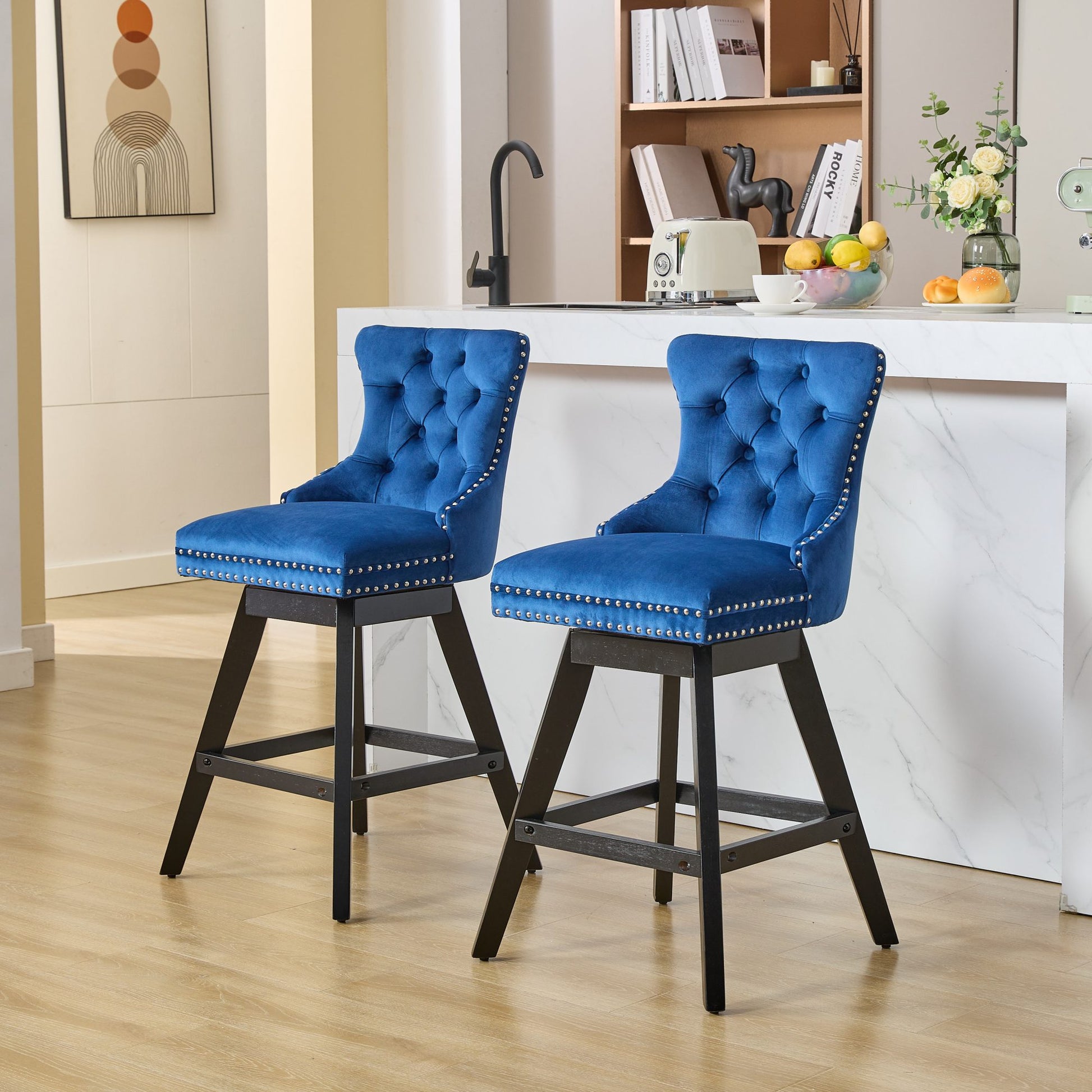 Tufted blue velvet bar stools with silver nailhead trim and black wood legs