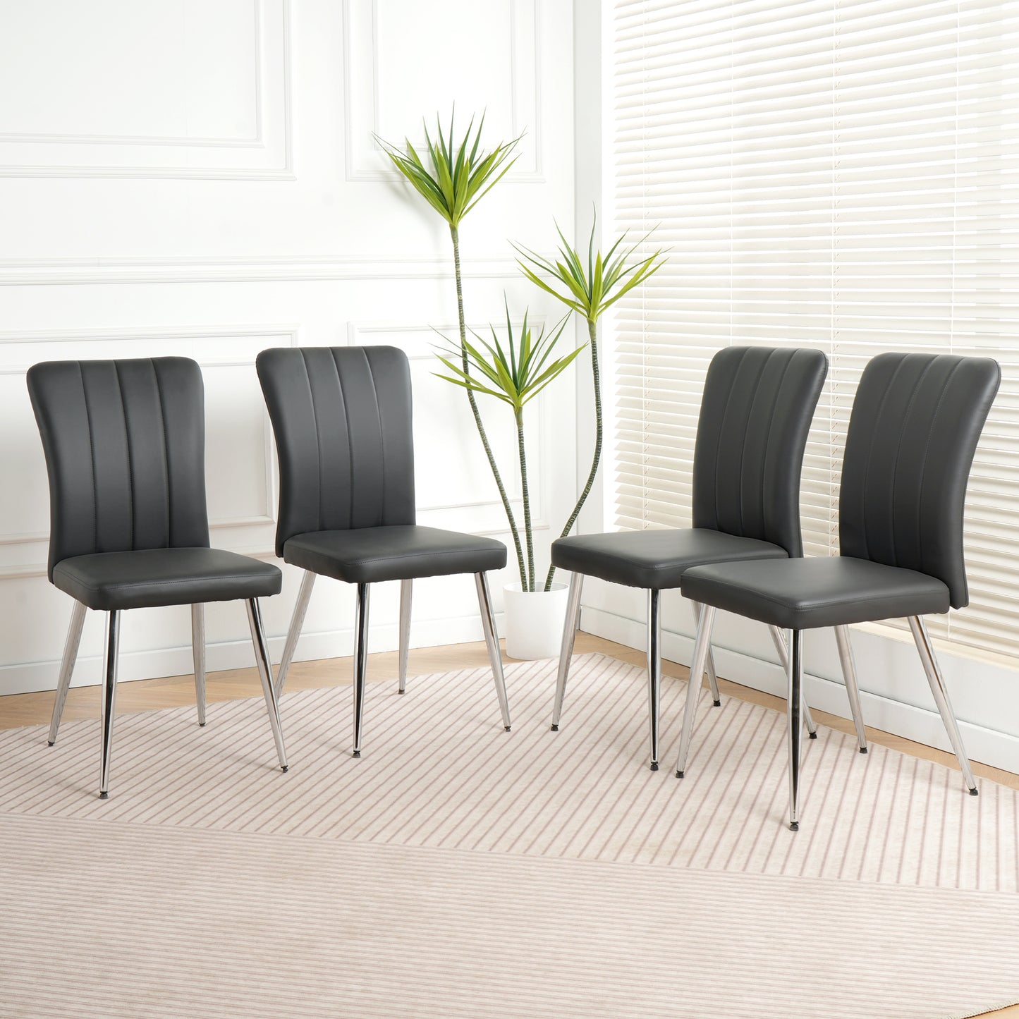 Set of four modern black faux leather dining chairs with chrome legs