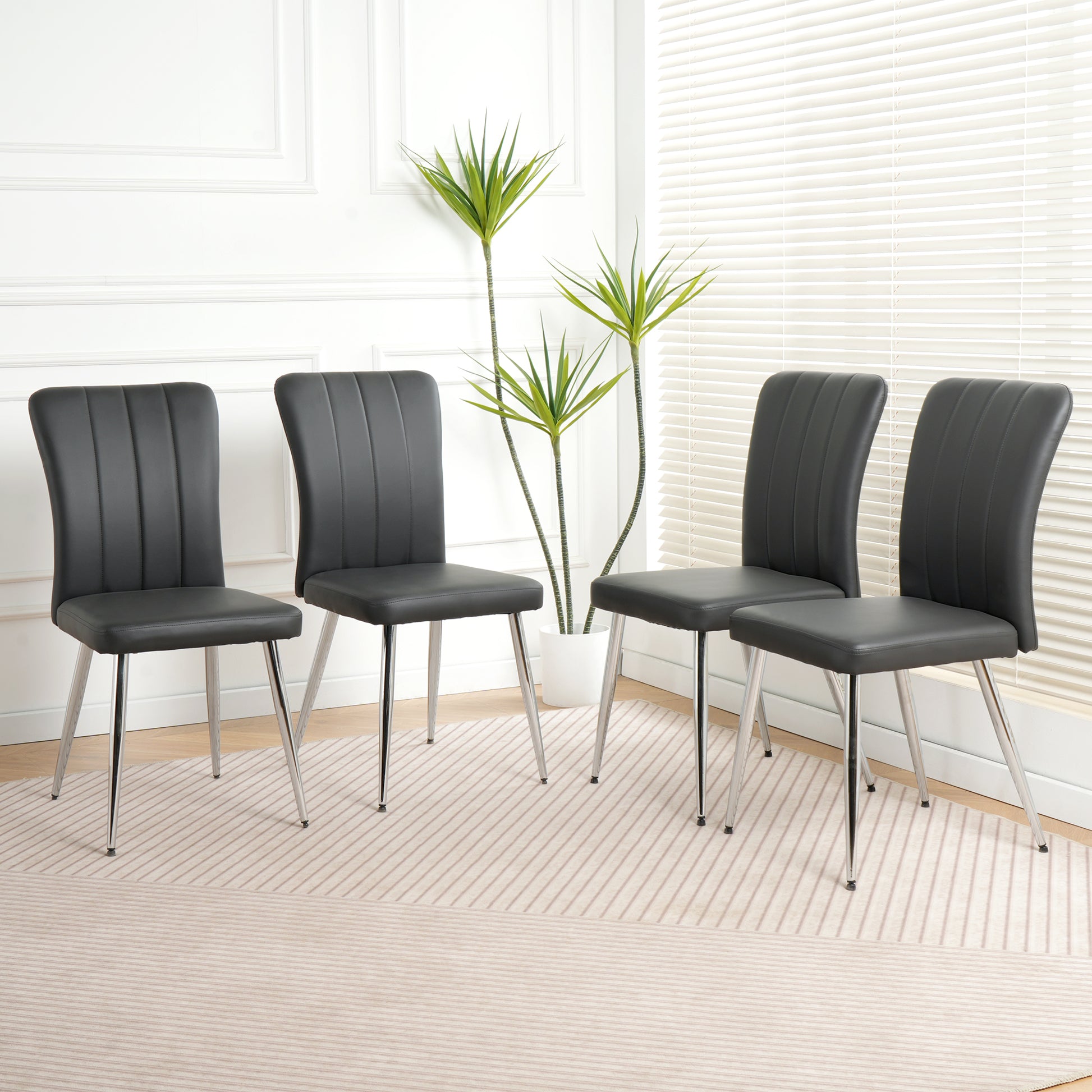 Set of four modern black faux leather dining chairs with chrome legs