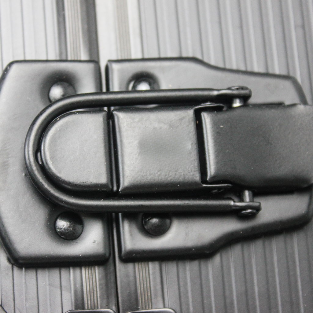 Black metal suitcase latch with textured surface