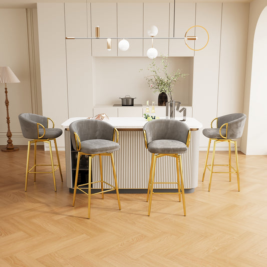 Four grey velvet swivel bar stools with gold legs and accents around a kitchen island