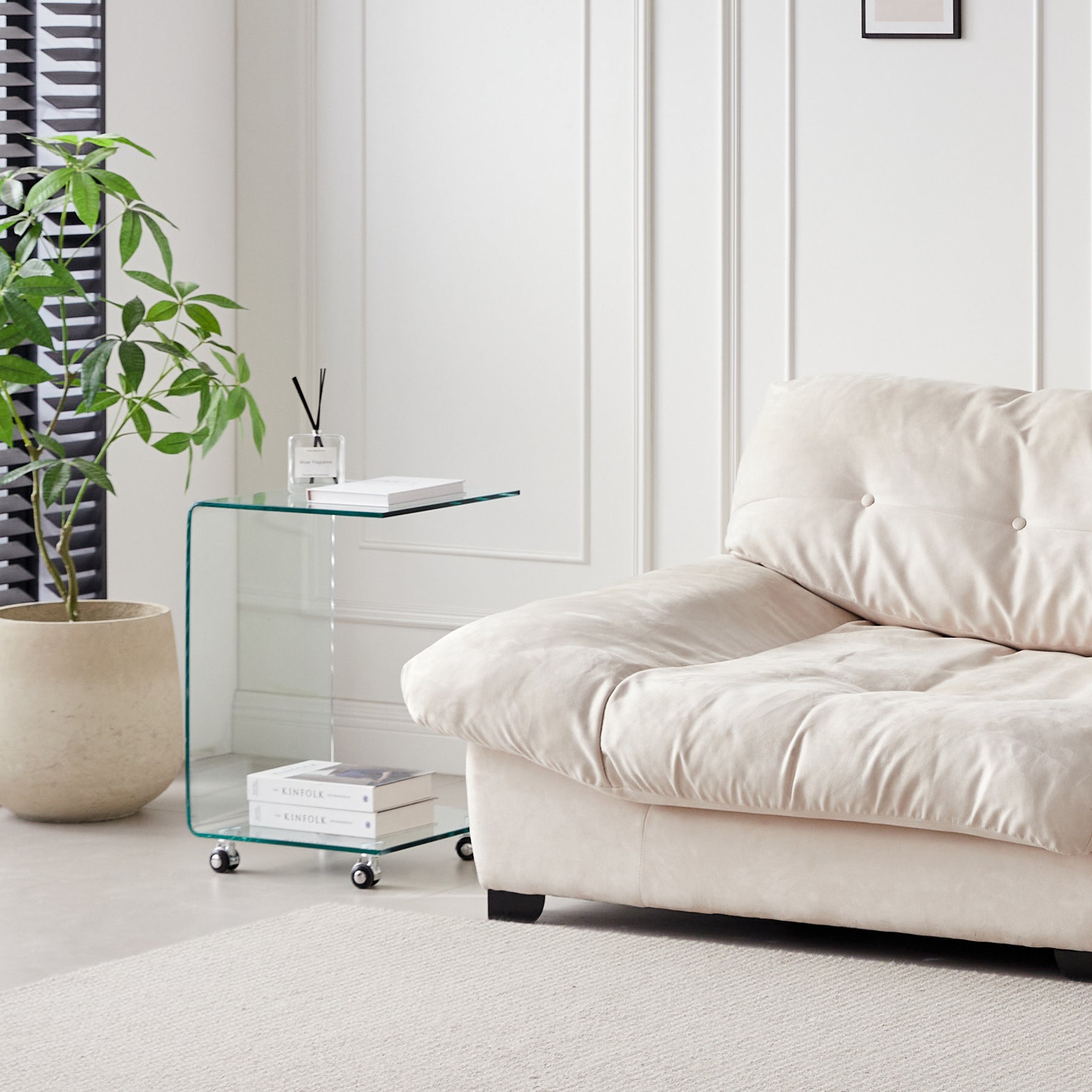 Cream tufted velvet sofa with low arms and dark wooden legs