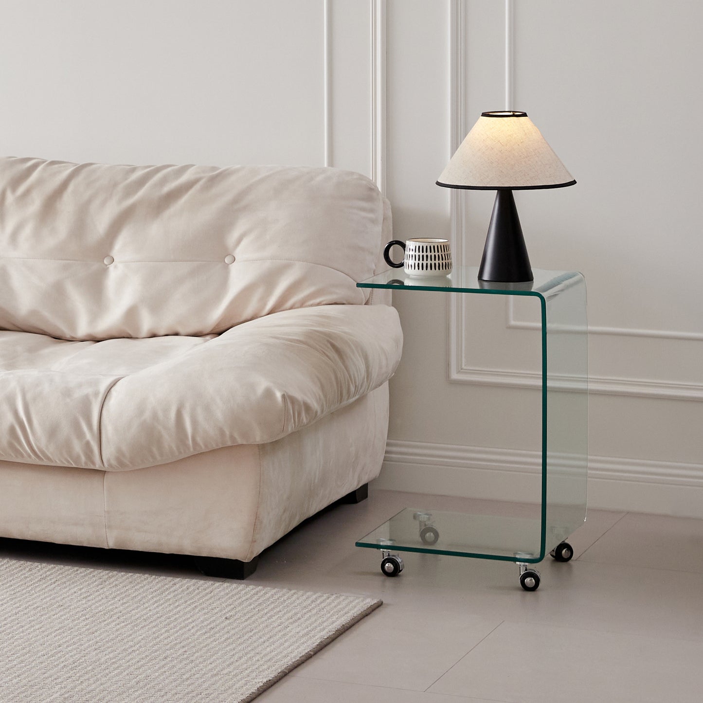 Cream tufted sofa next to a modern clear acrylic Ctable with wheels