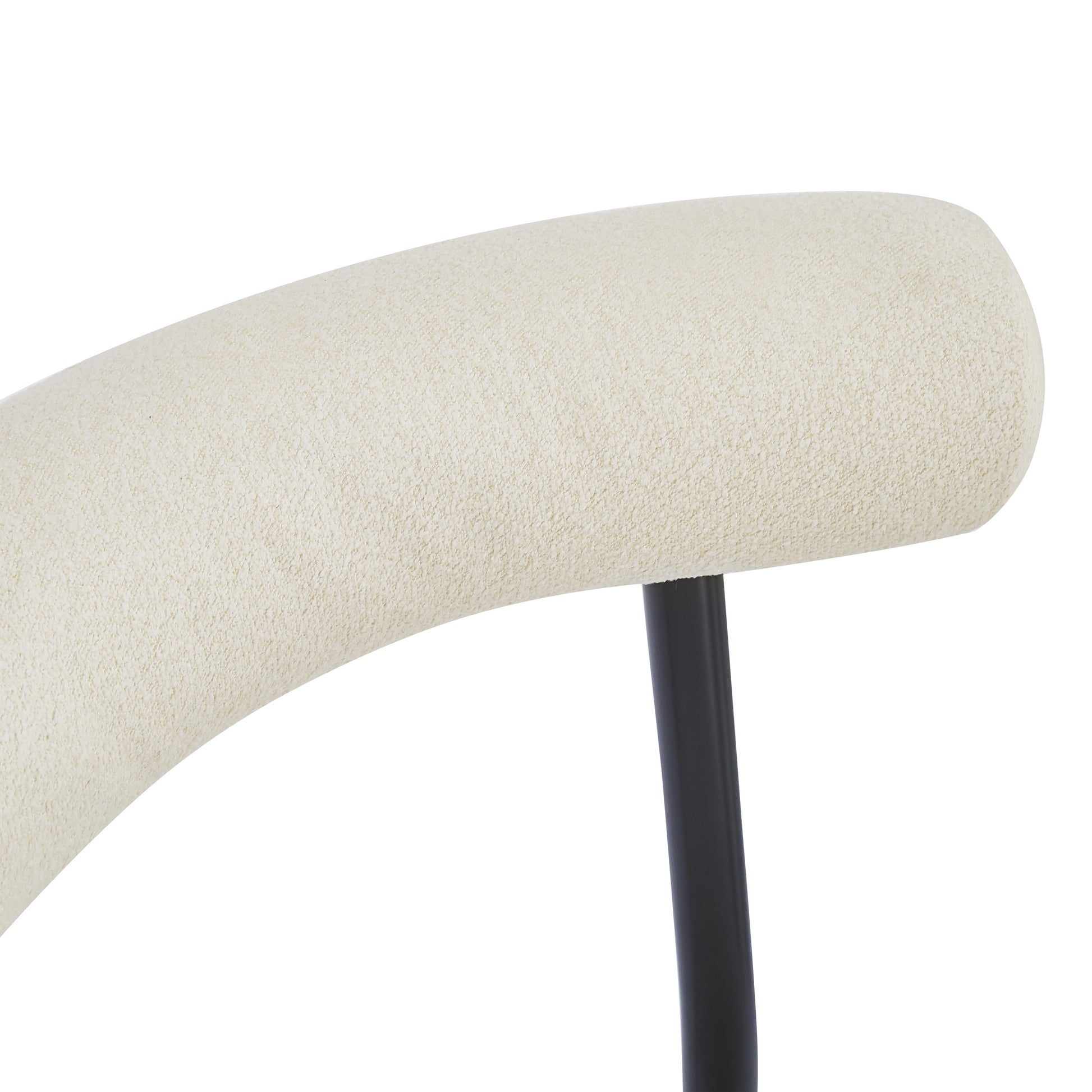 Cream textured upholstery on curved chair back with black metal leg