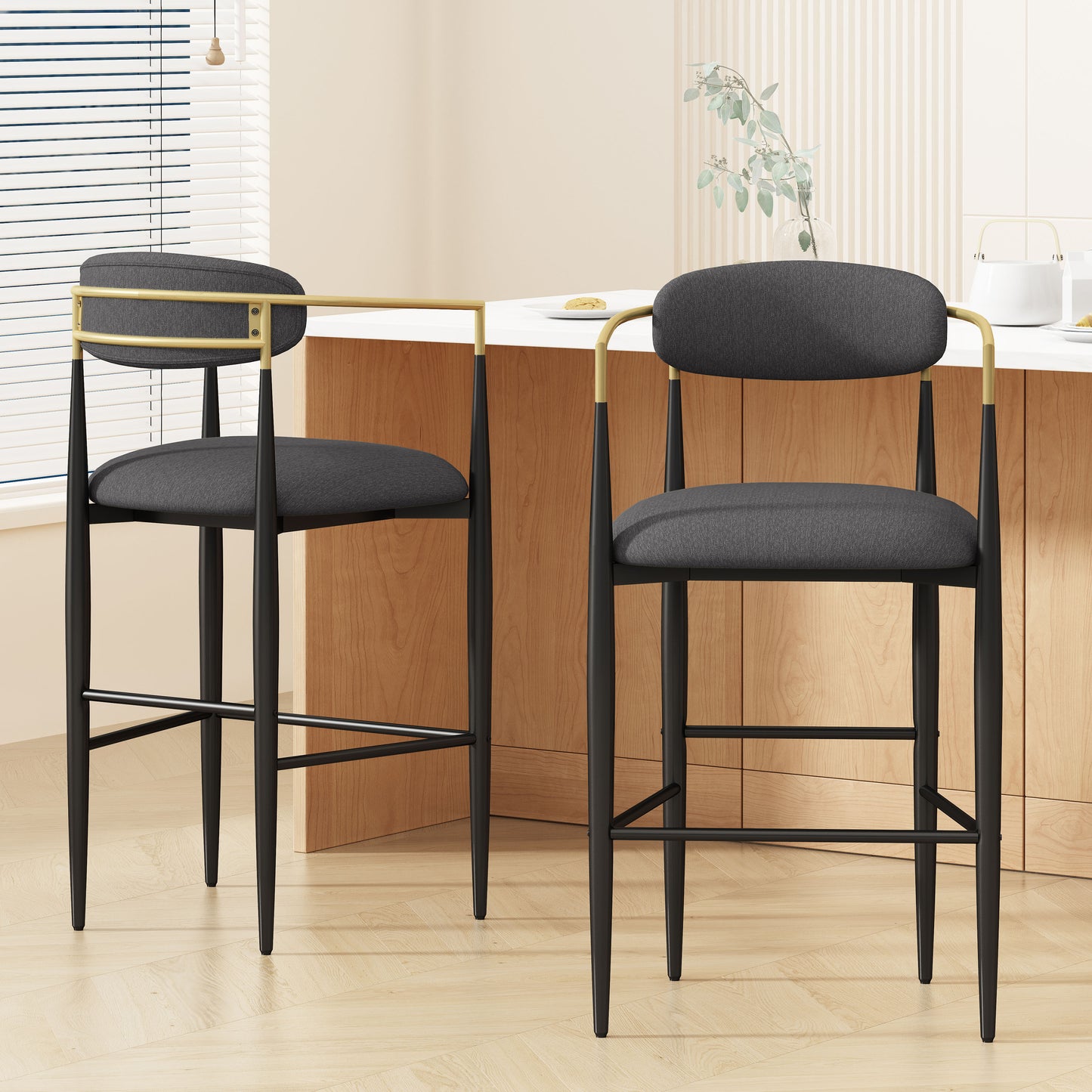 Dark gray upholstered bar stool with gold accents and black legs