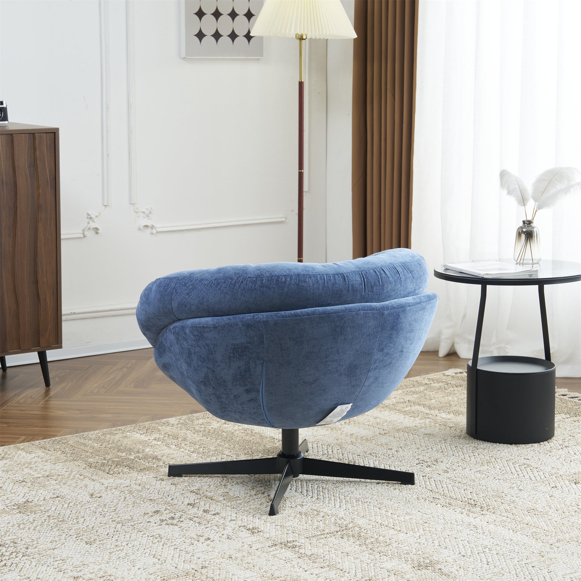 Blue upholstered accent chair with swivel base on woven rug