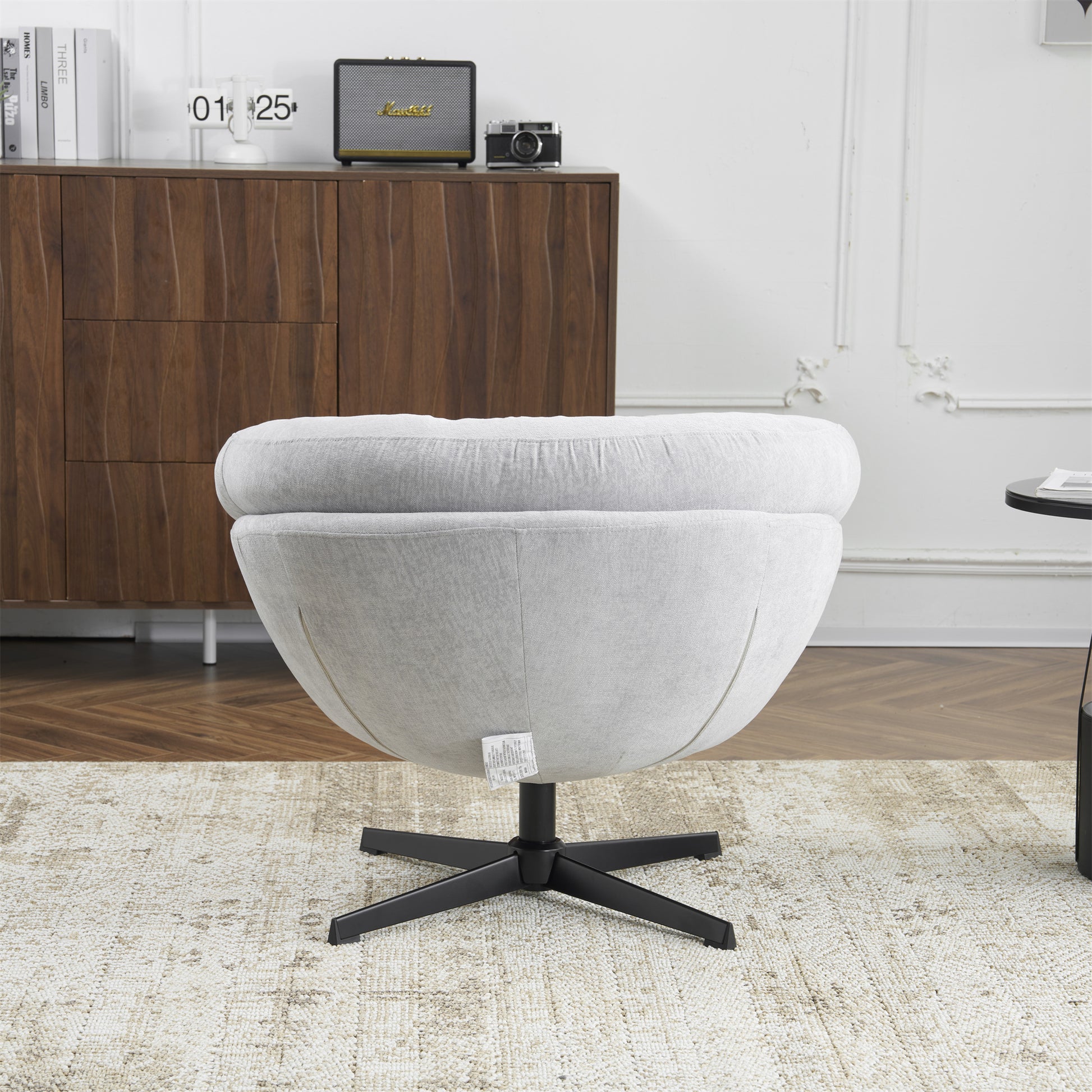 Light gray fabric accent chair with plush rounded seat and swiveling base