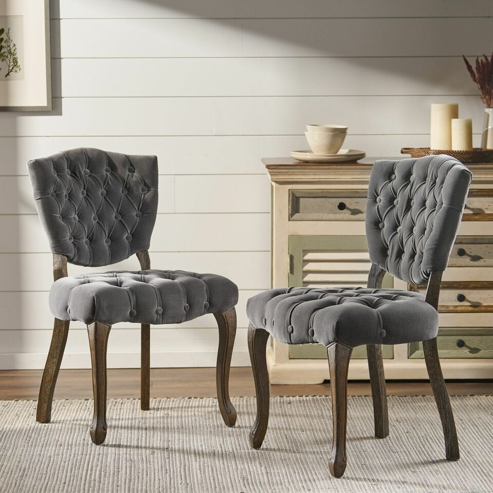Dark grey velvet accent chair with tufted upholstery and carved wooden legs