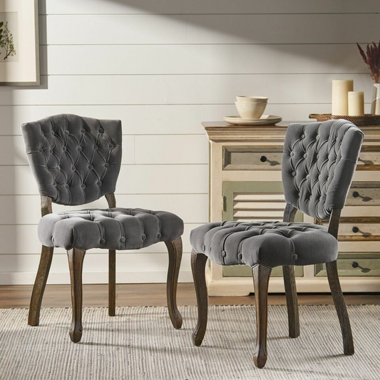 Dark grey velvet accent chair with tufted upholstery and carved wooden legs