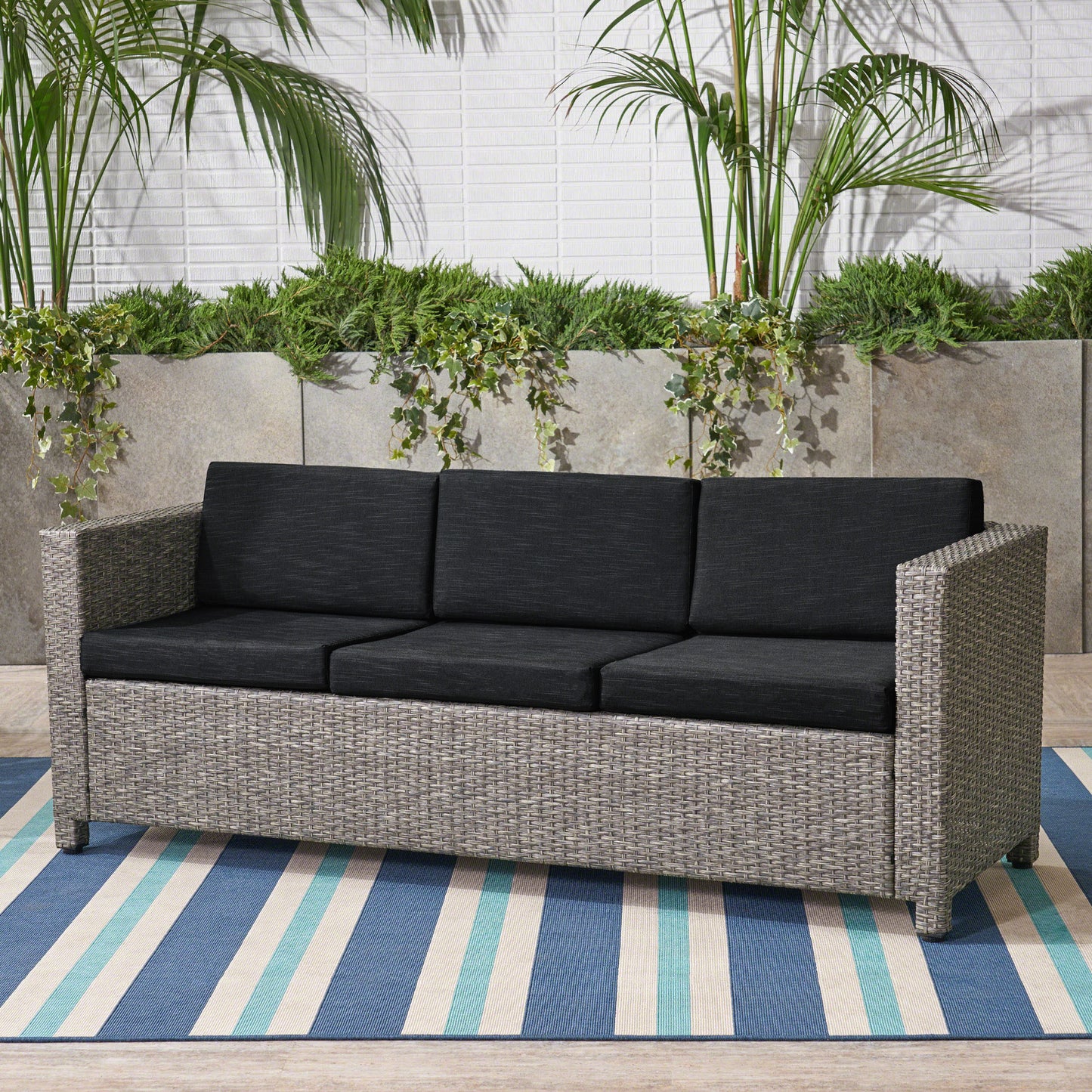 Gray wicker outdoor sofa with dark gray cushions