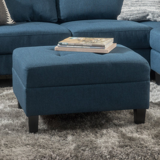 Deep blue fabric ottoman with tufted top and wooden legs