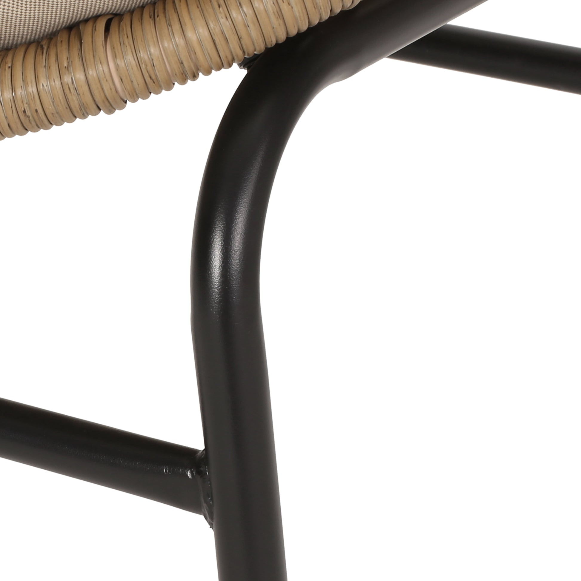 Closeup of woven rattan detail on a black metal chair frame