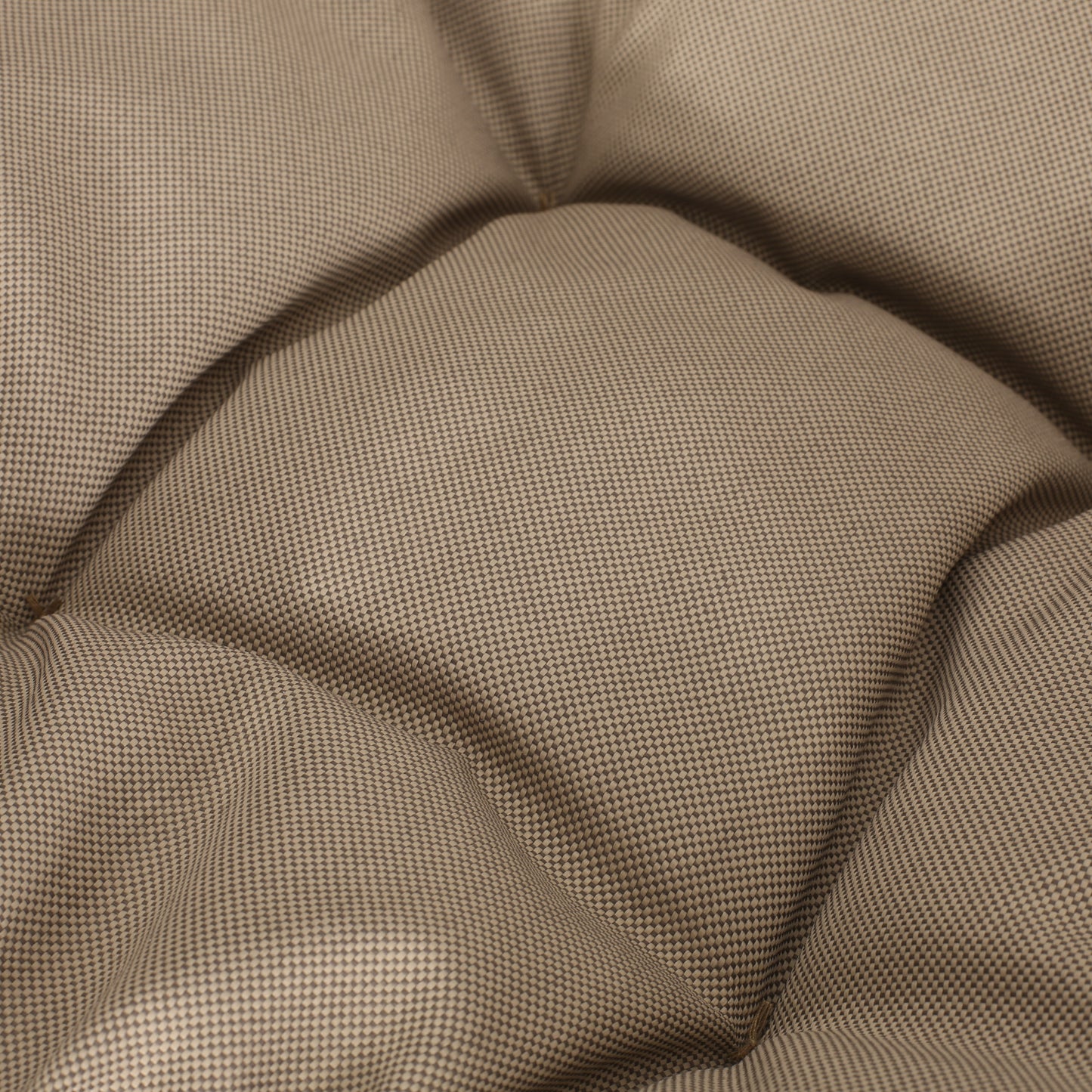 Tufted beige textured cushion fabric closeup