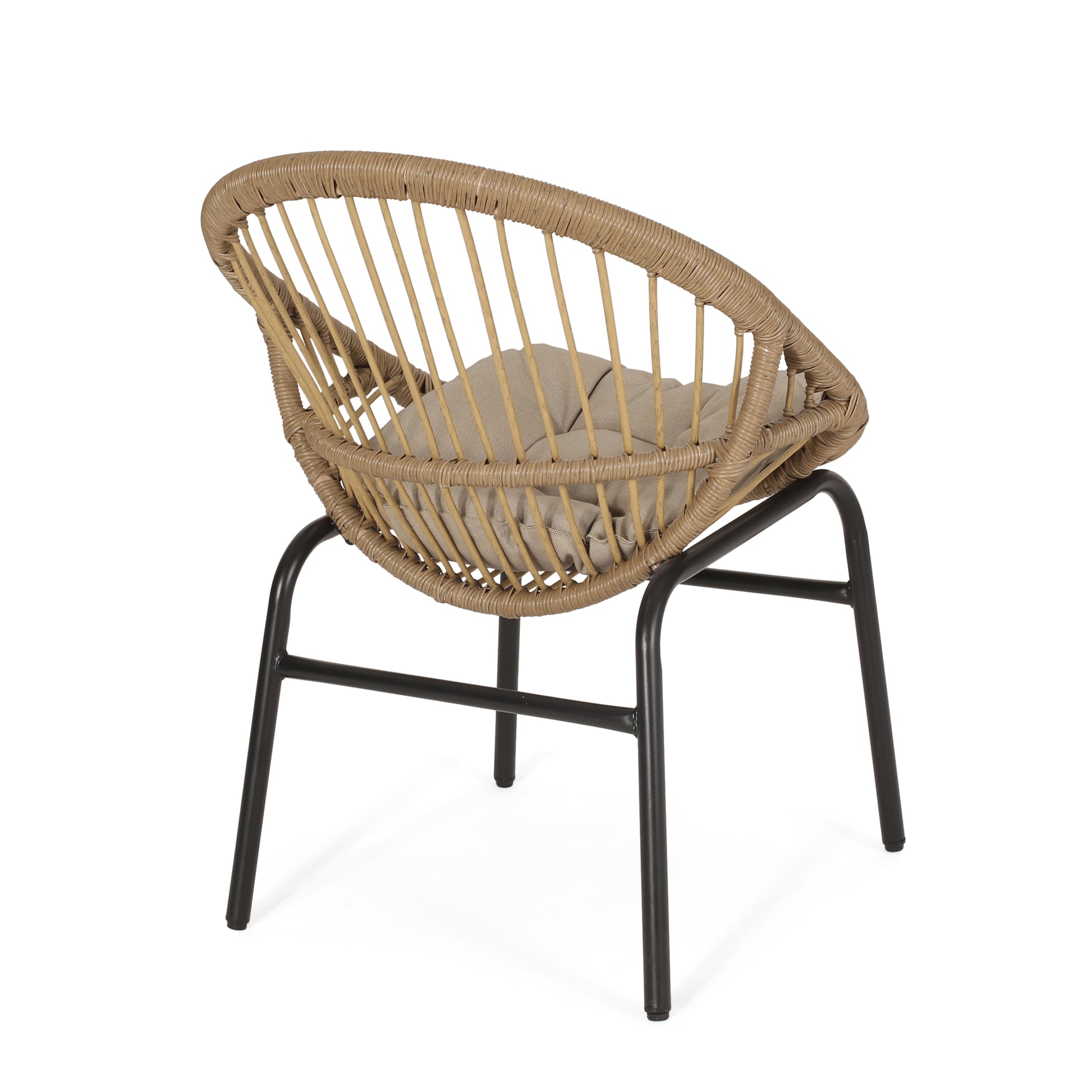 Tan rattan accent chair with black metal legs and neutral cushion