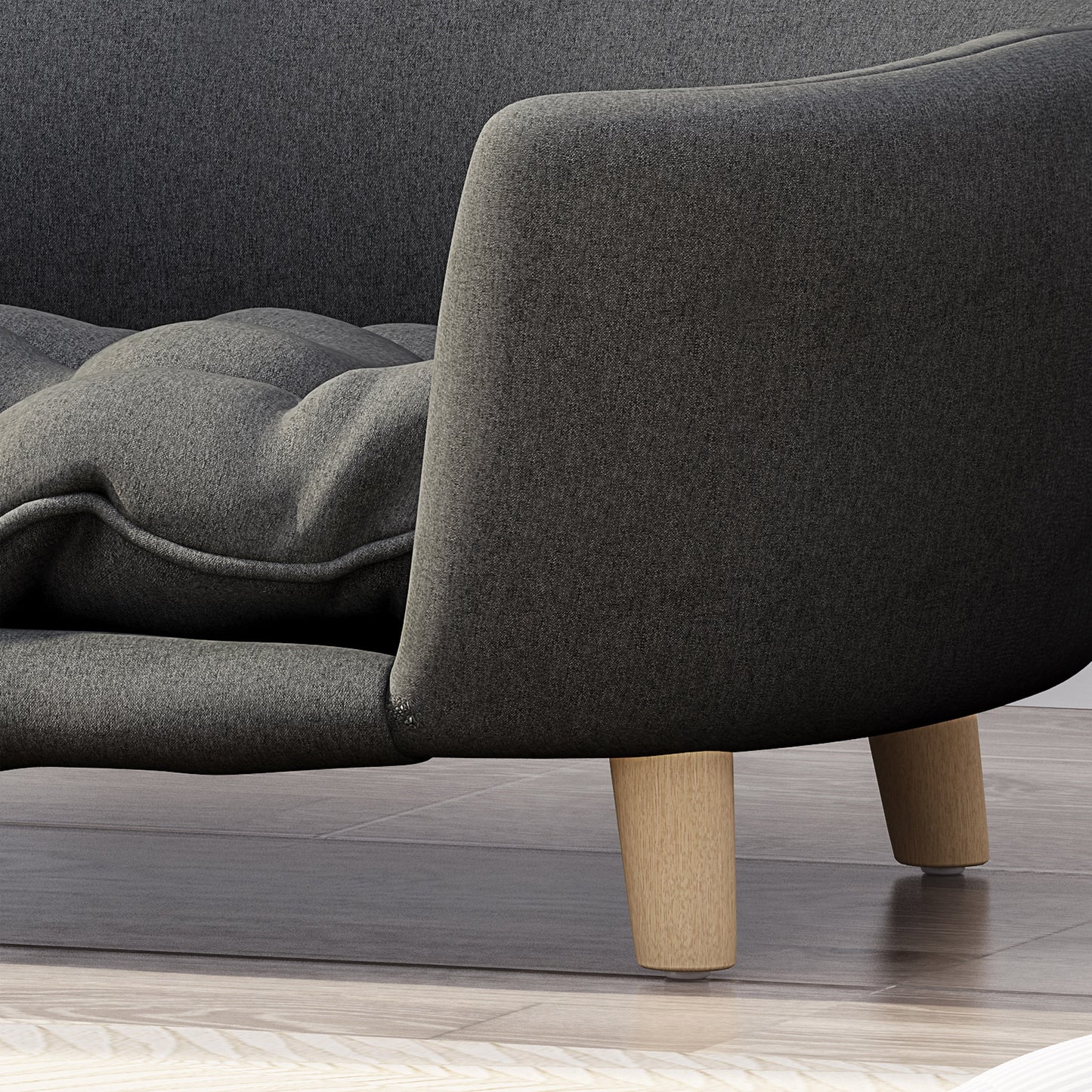 Dark gray fabric sofa detail with tufted cushion and wooden legs