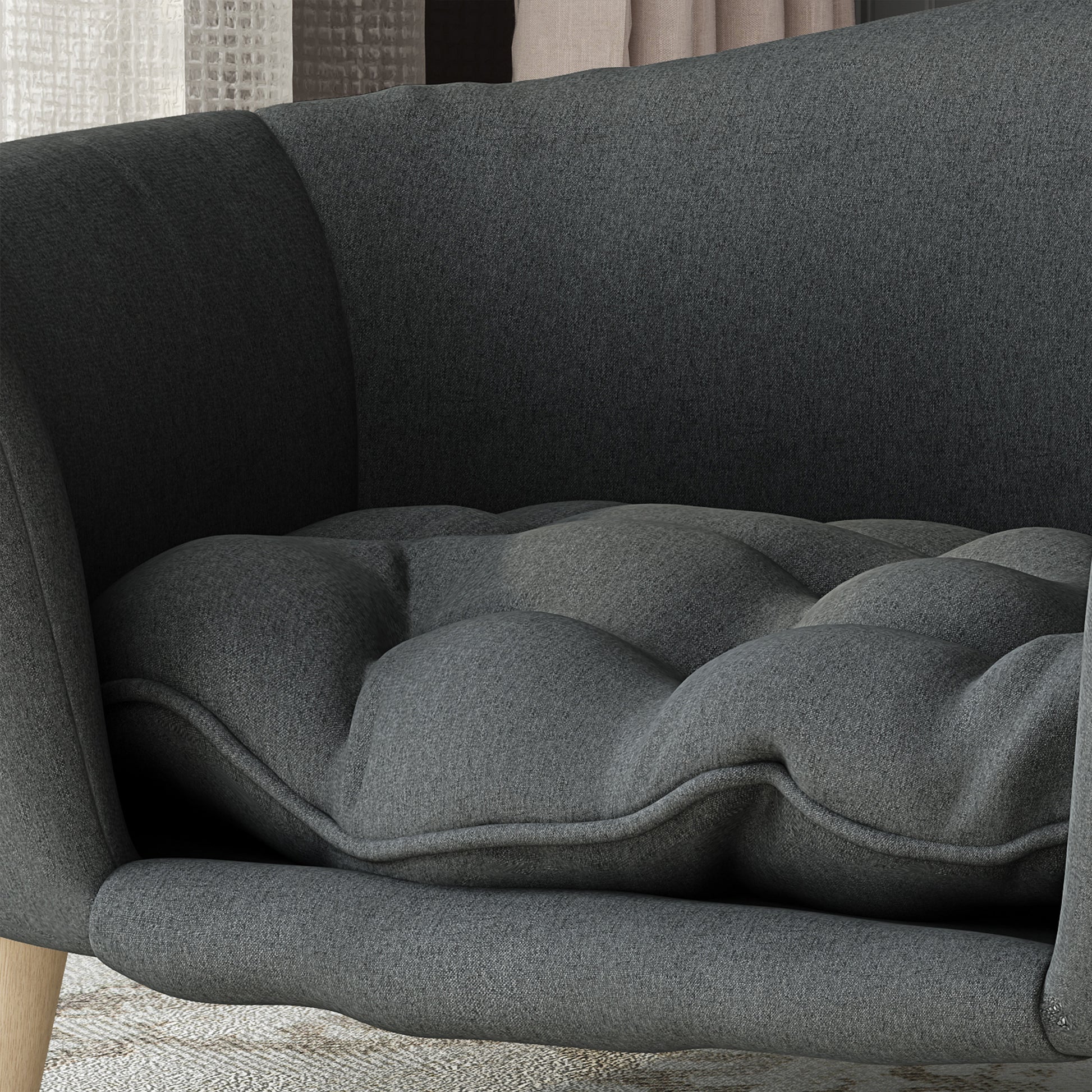 Dark gray upholstered armchair with a deep tufted cushion