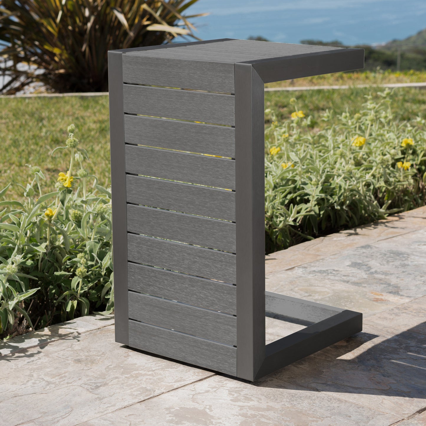 Gray Cshaped outdoor side table with slatted composite wood and metal frame