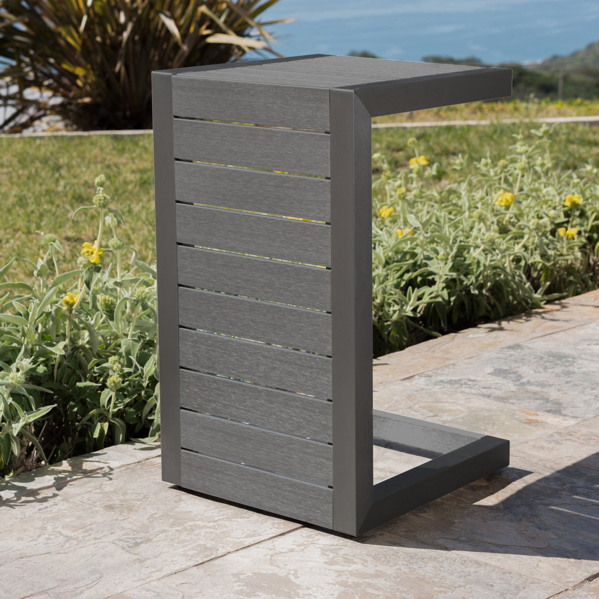 Gray Cshaped outdoor side table with slatted composite wood and metal frame