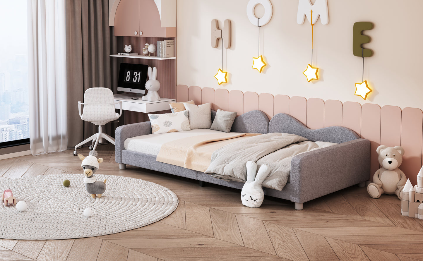 Gray toddler bed with plush toys and starshaped wall decor
