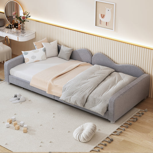 Grey upholstered daybed with plush bedding and pillows