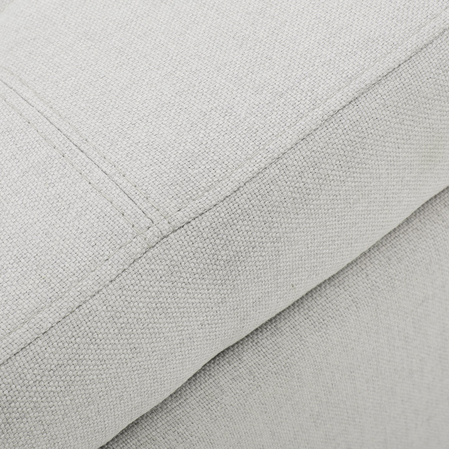 Closeup of light grey linen fabric texture with stitching detail