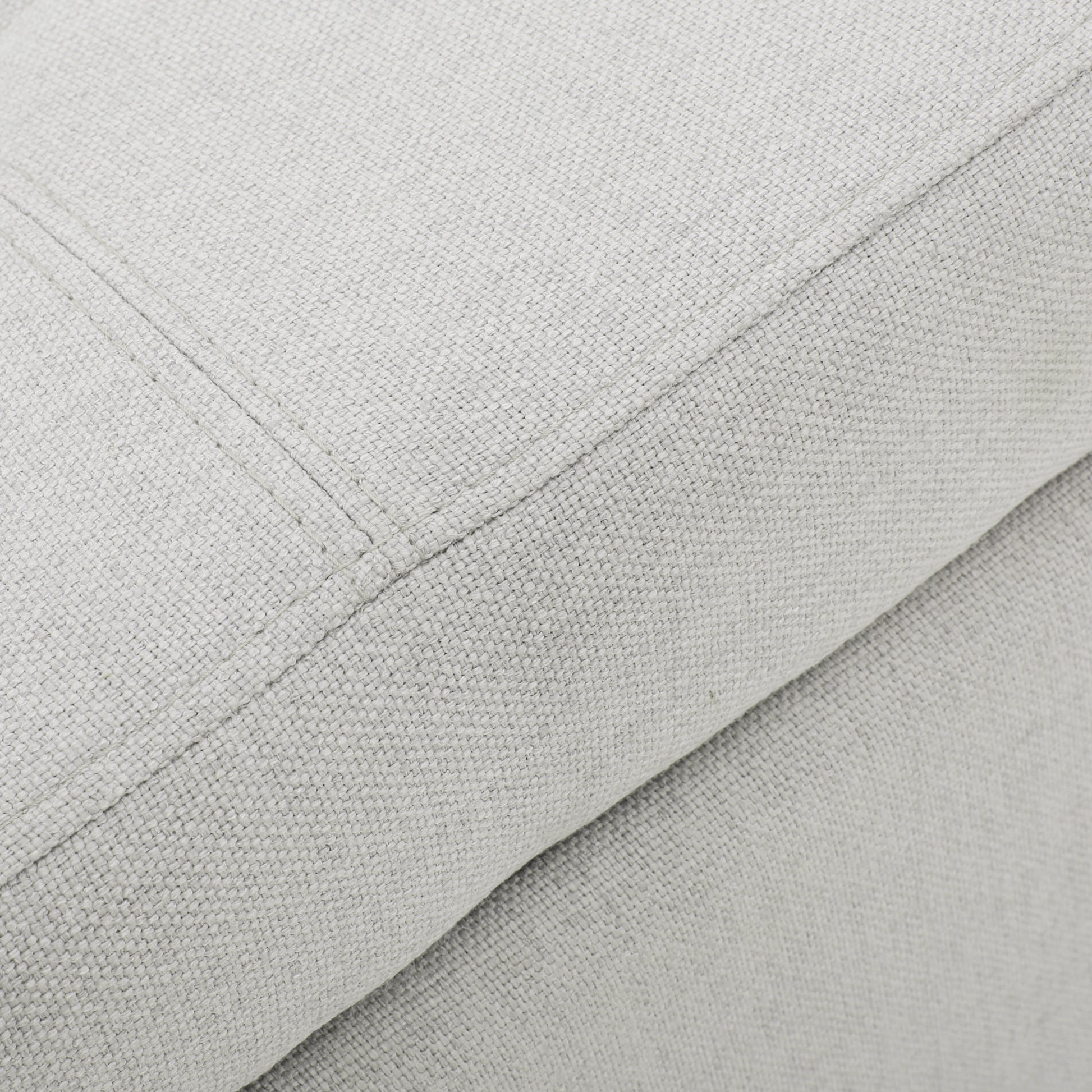 Closeup of light grey linen fabric texture with stitching detail