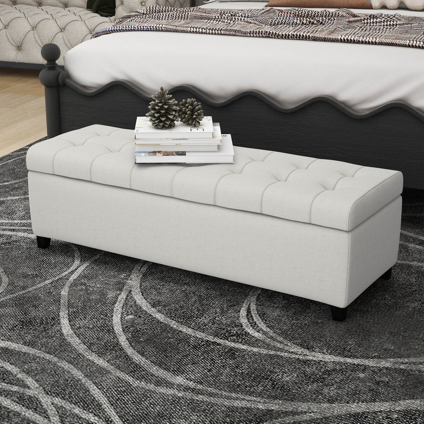 Tufted linen storage bench in light beige with decorative pillows and books