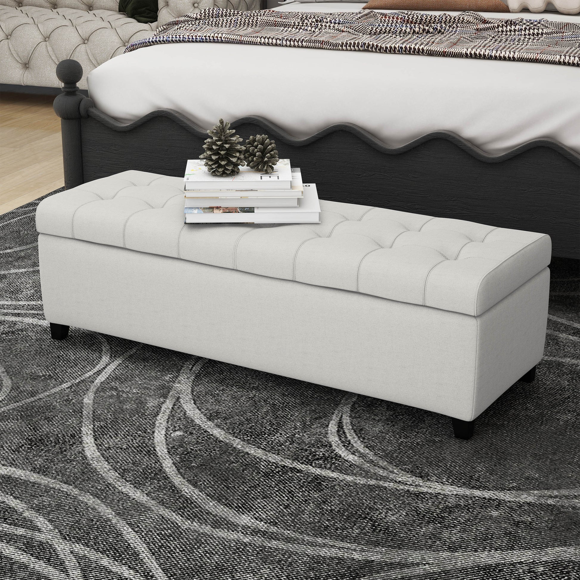 Tufted linen storage bench in light beige with decorative pillows and books