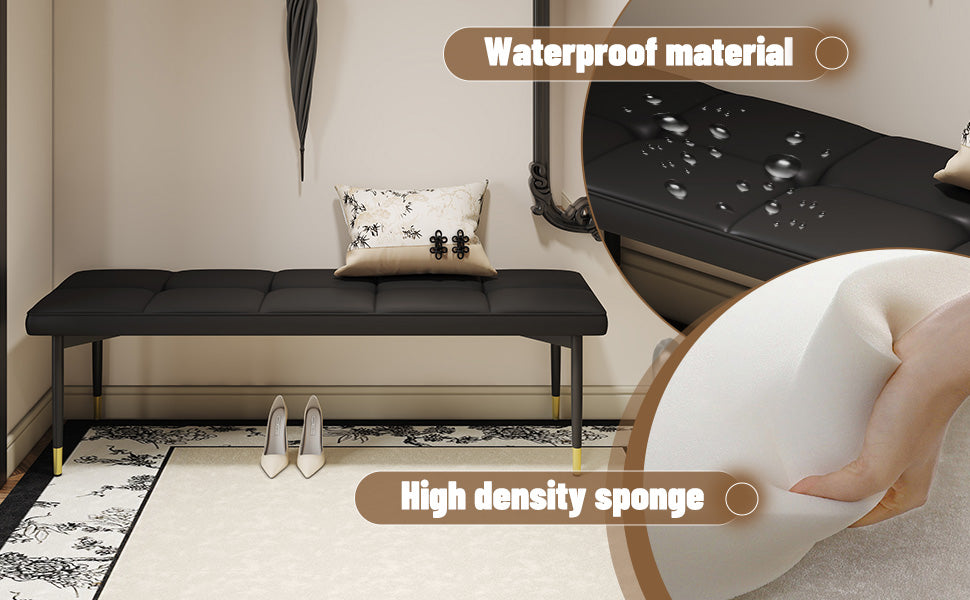 Black tufted vegan leather bench with goldtipped legs
