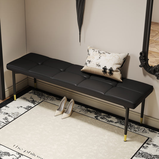 Black faux leather bench with tufted seat and goldcapped legs
