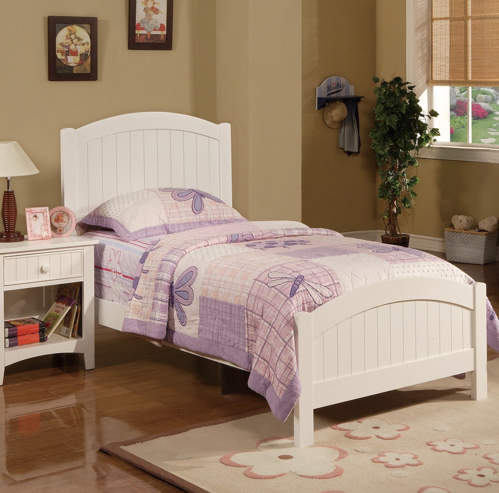 White wooden twin bed with purple butterfly quilt