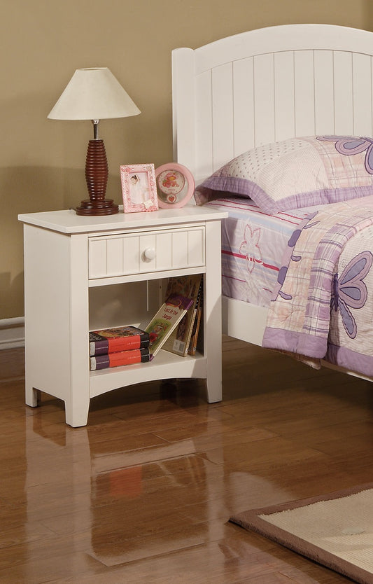 White wooden nightstand with drawer and open shelf displaying books